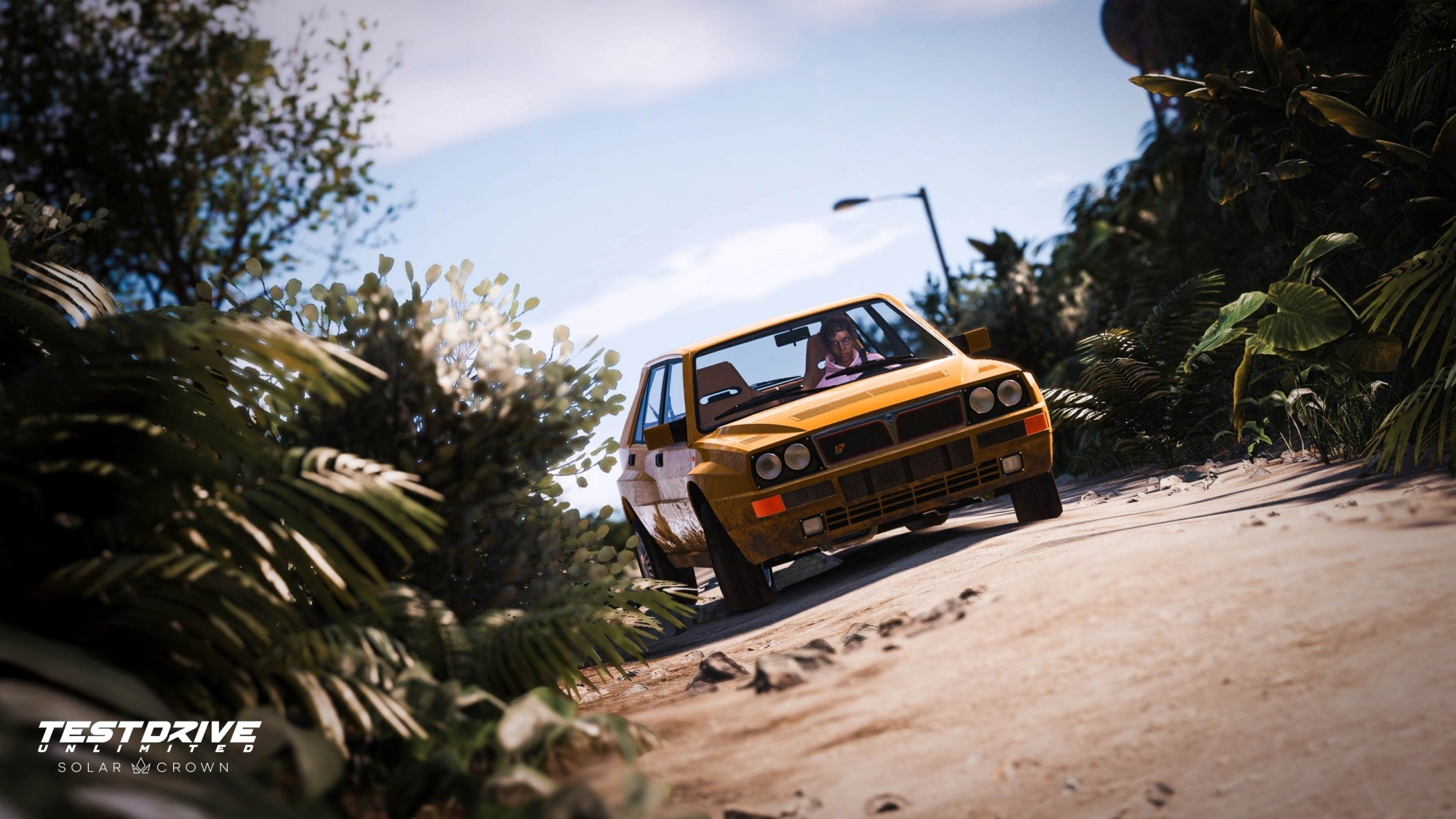 Auto classico giallo che guida su una strada sterrata, sfondo tropicale, gioco Test Drive Unlimited Solar Crown.