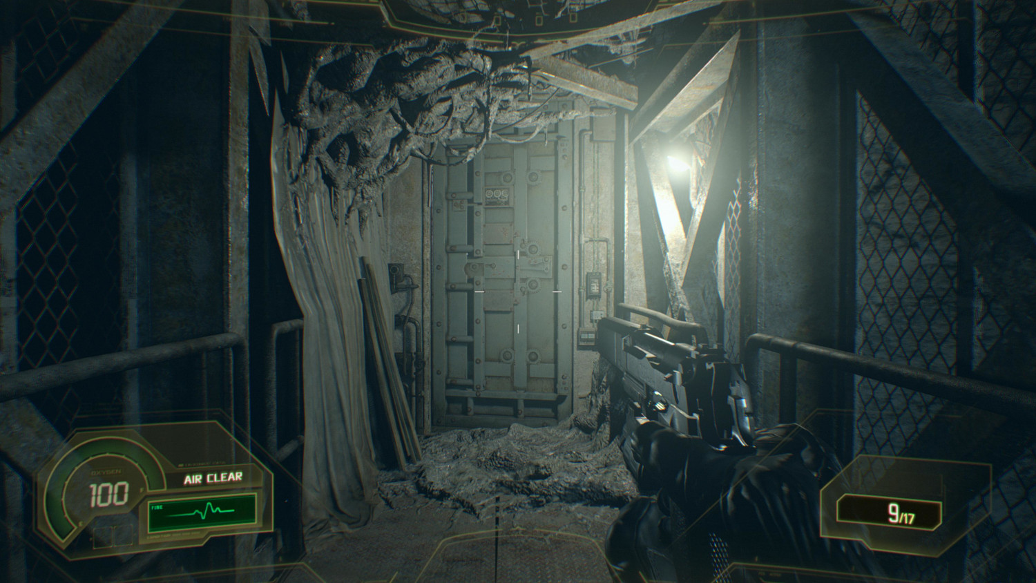Vue à la première personne dans un couloir industriel sombre avec une arme levée.