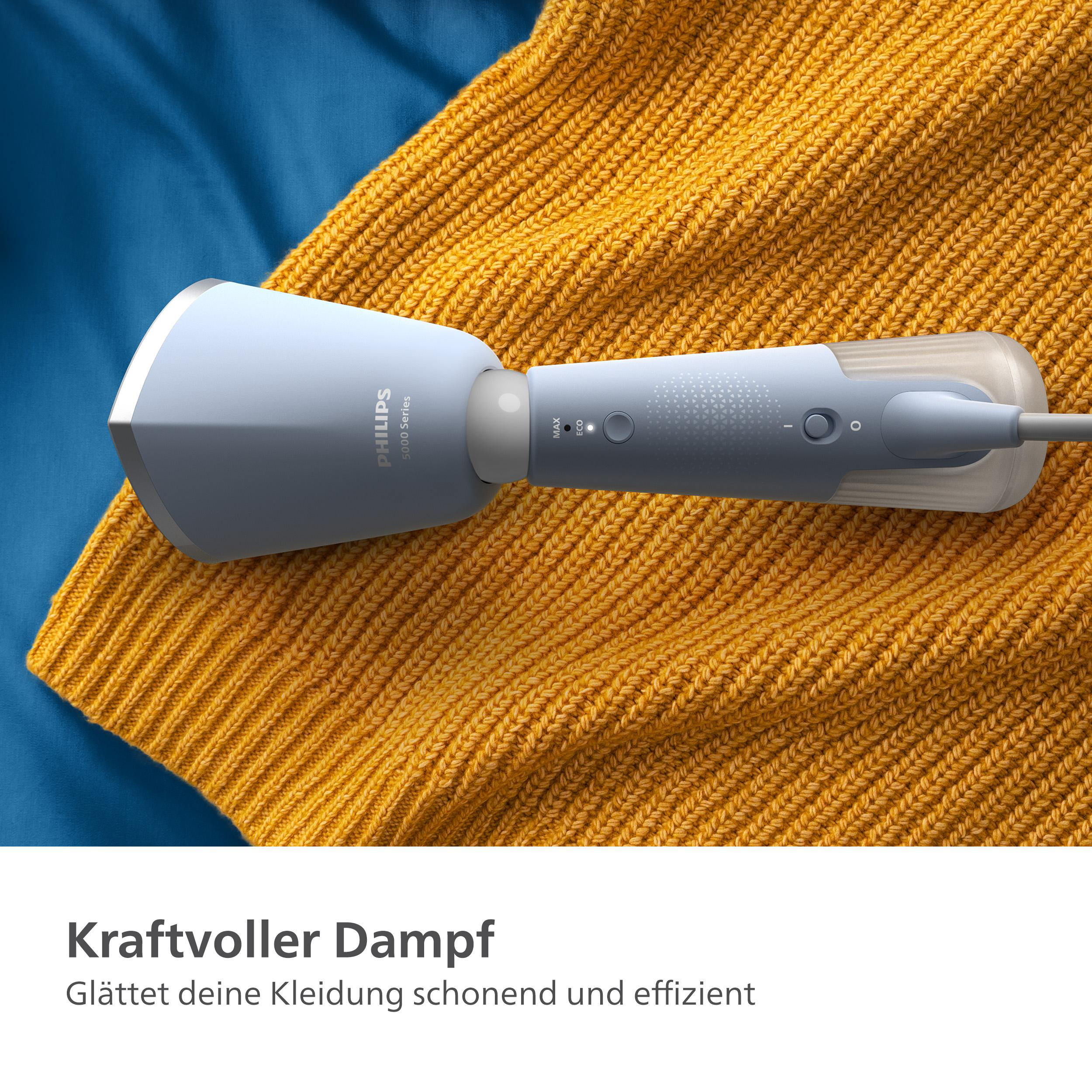 Ein hellblauer Philips-Dampfgarer auf einem gelben Pullover. Das Gerät steht auf einer Oberfläche.