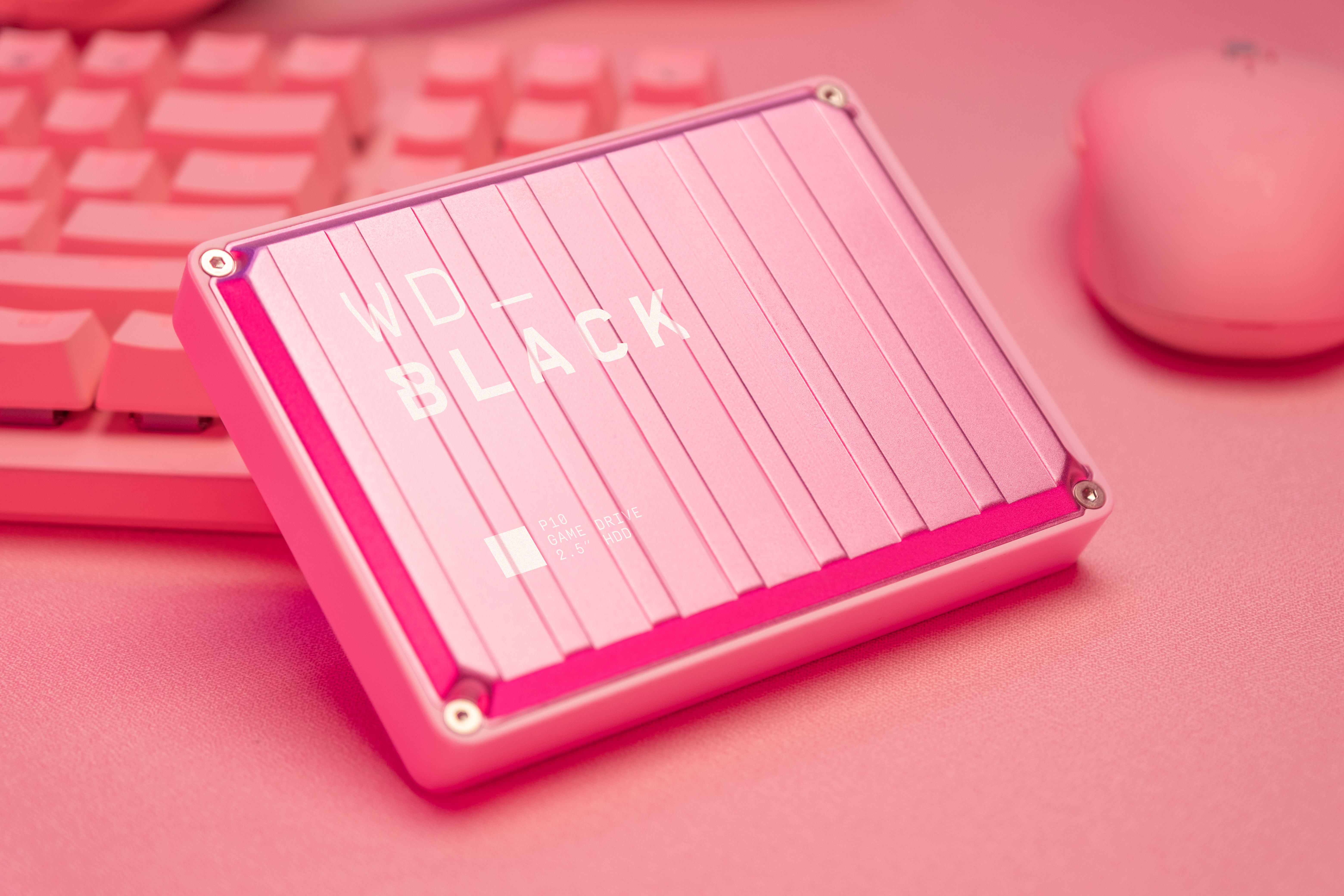 Eine pinkfarbene WD_BLACK P40 Game Drive SSD auf einer pinkfarbenen Oberfläche, mit Tastatur und Maus.