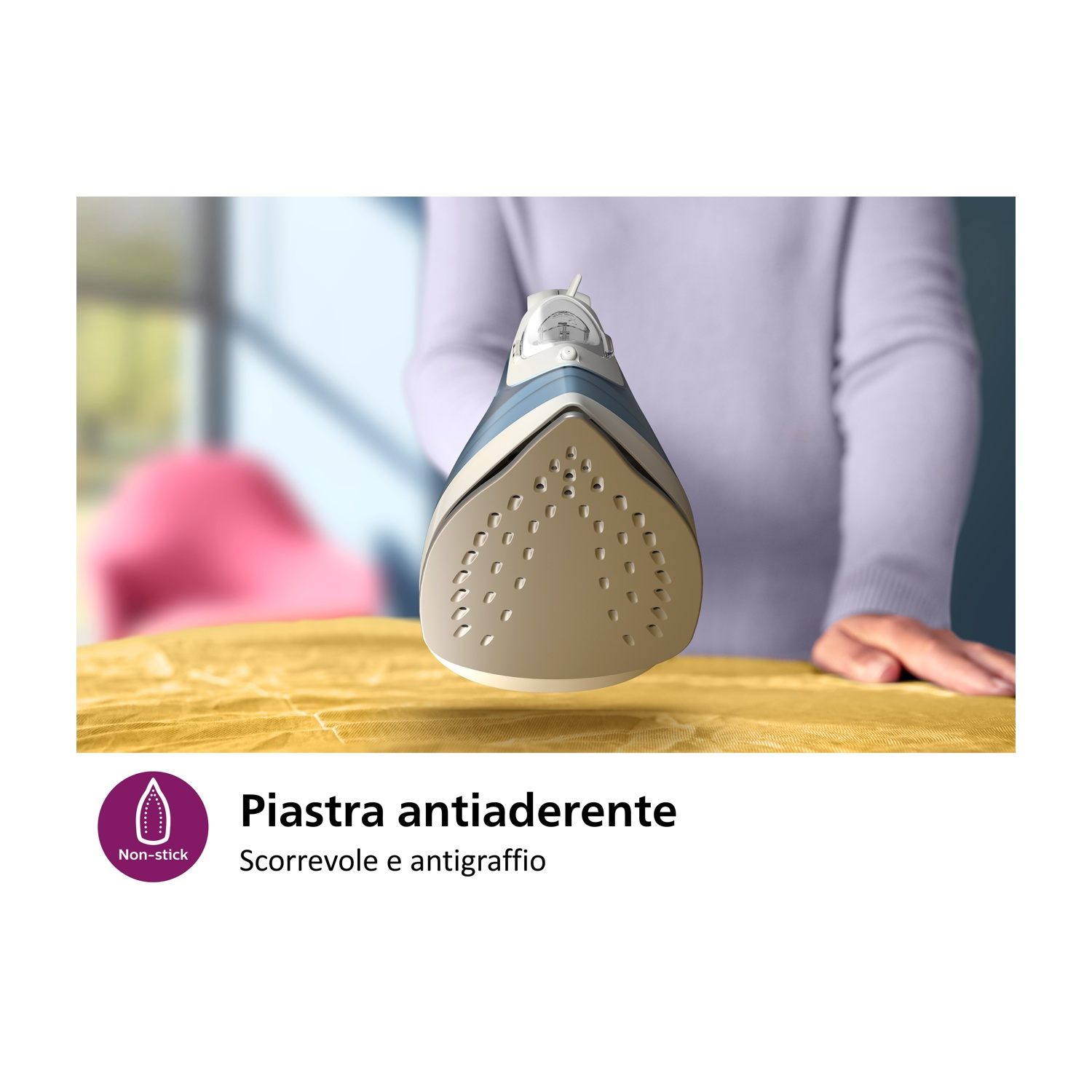 Primo piano di un ferro da stiro bianco e blu che stira un tessuto giallo. Etichetta antiaderente.