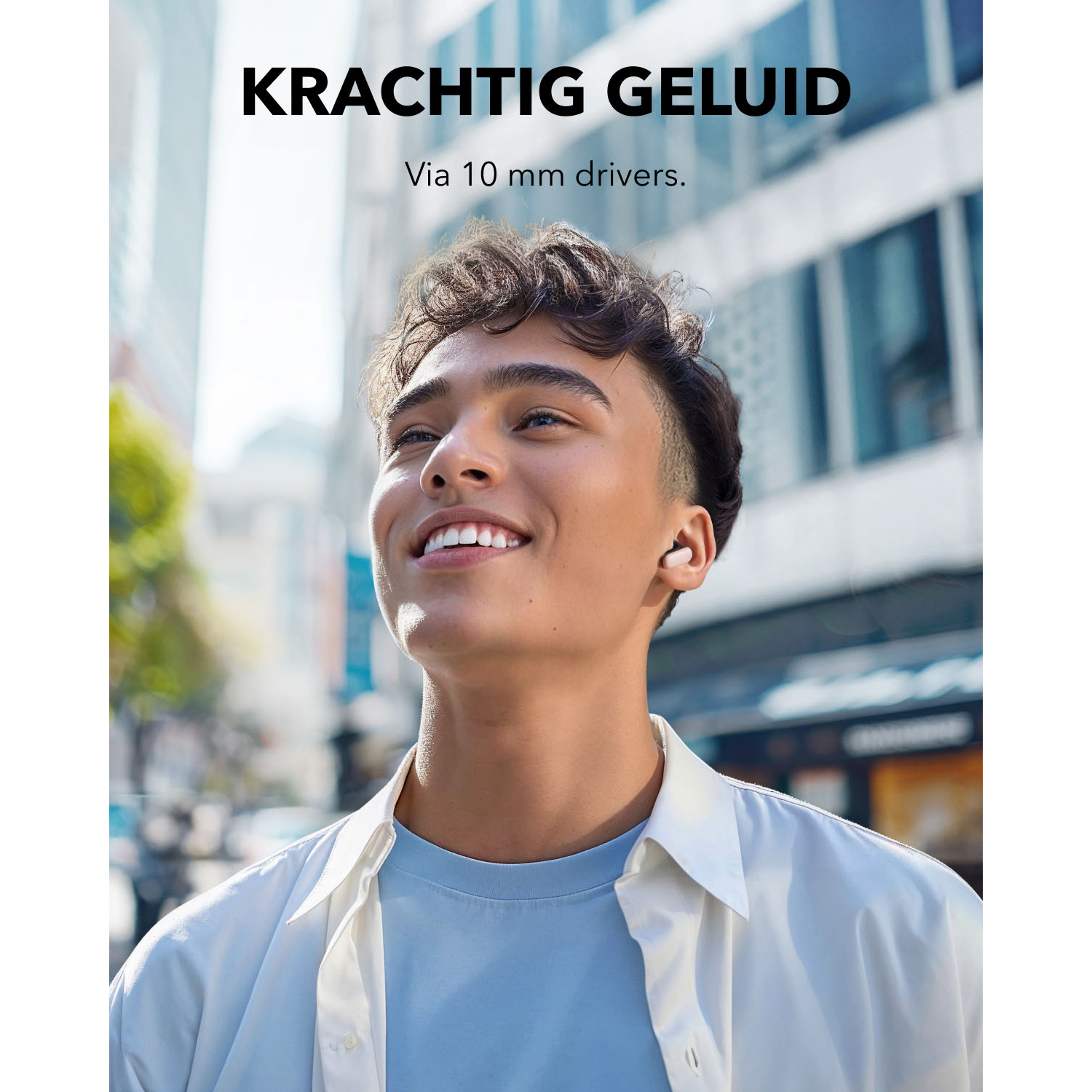 Man lacht met oortjes in, stadsachtergrond, tekst: Krachtig Geluid.