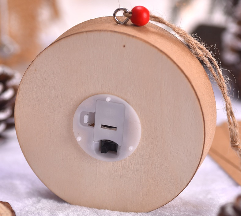 Drewniana ozdoba ze światłem i komorą baterii. Czerwony koralik na sznurku.