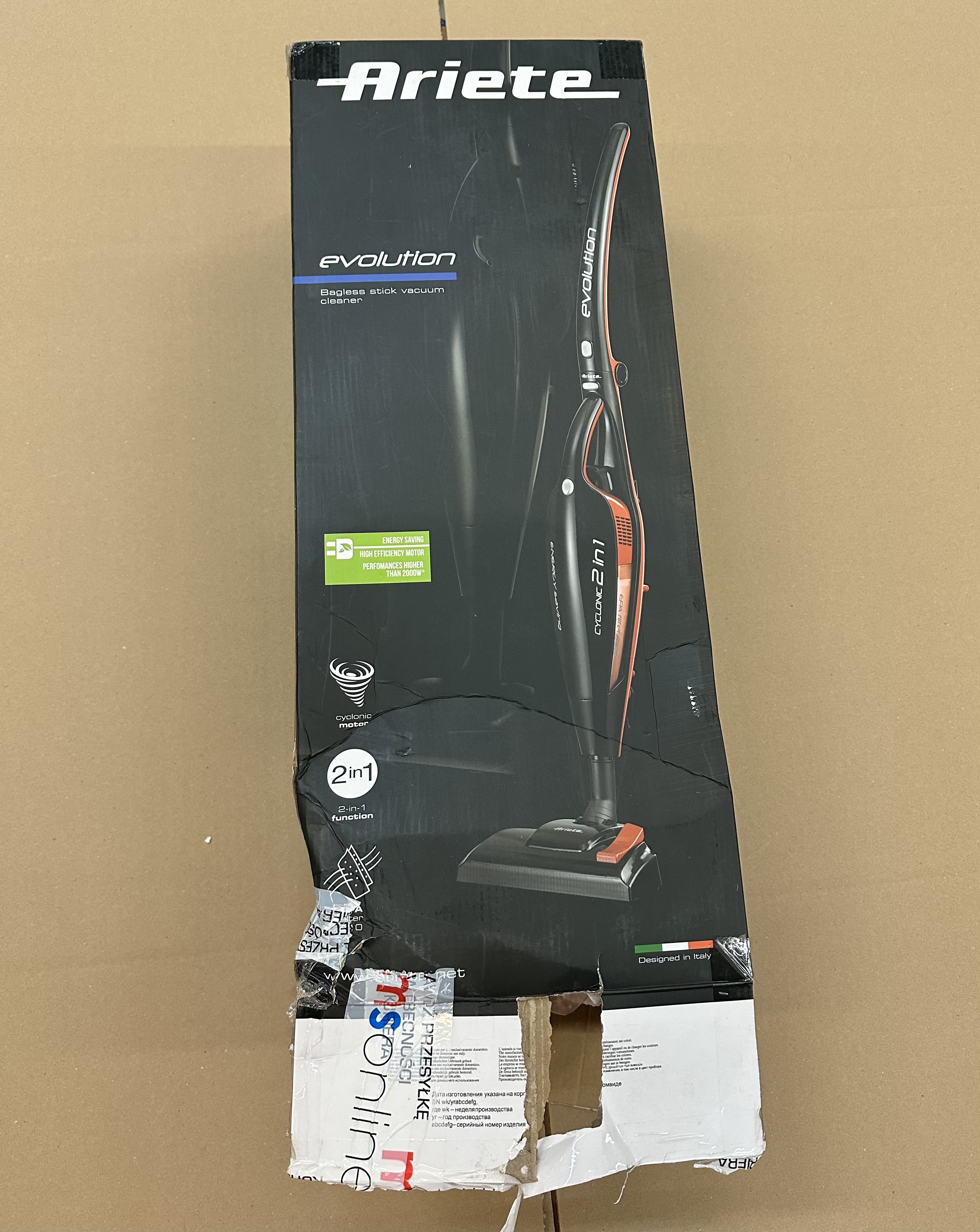 Uszkodzone pudełko odkurzacza z logo Ariete i szczegółami produktu.