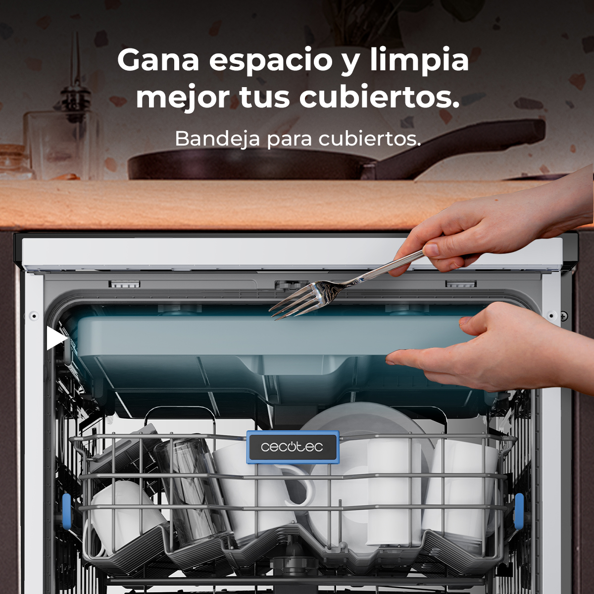 Una mano coloca una bandeja con cubiertos en un lavavajillas abierto.