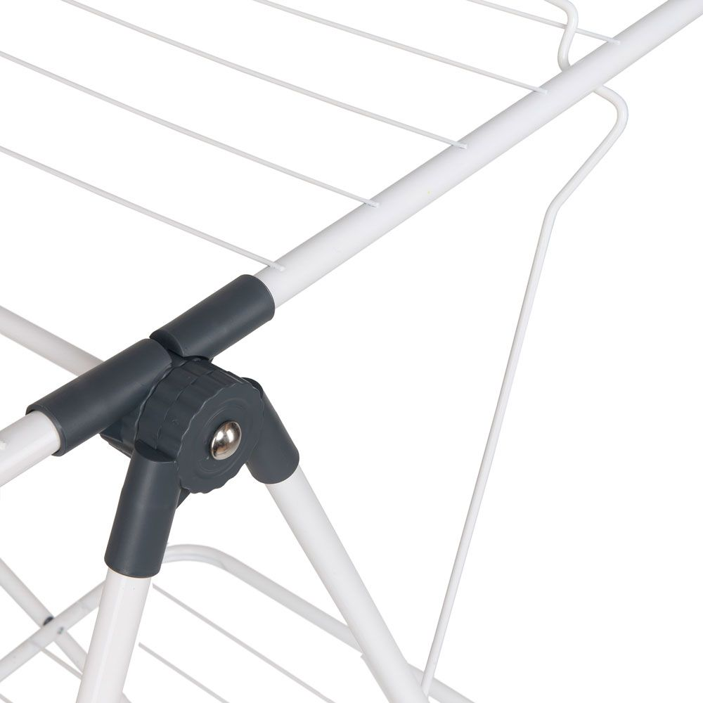 Zbliżenie białego metalowego stojaka do suszenia. Widoczny ciemnoszary przegub i okrągłe pokrętło.