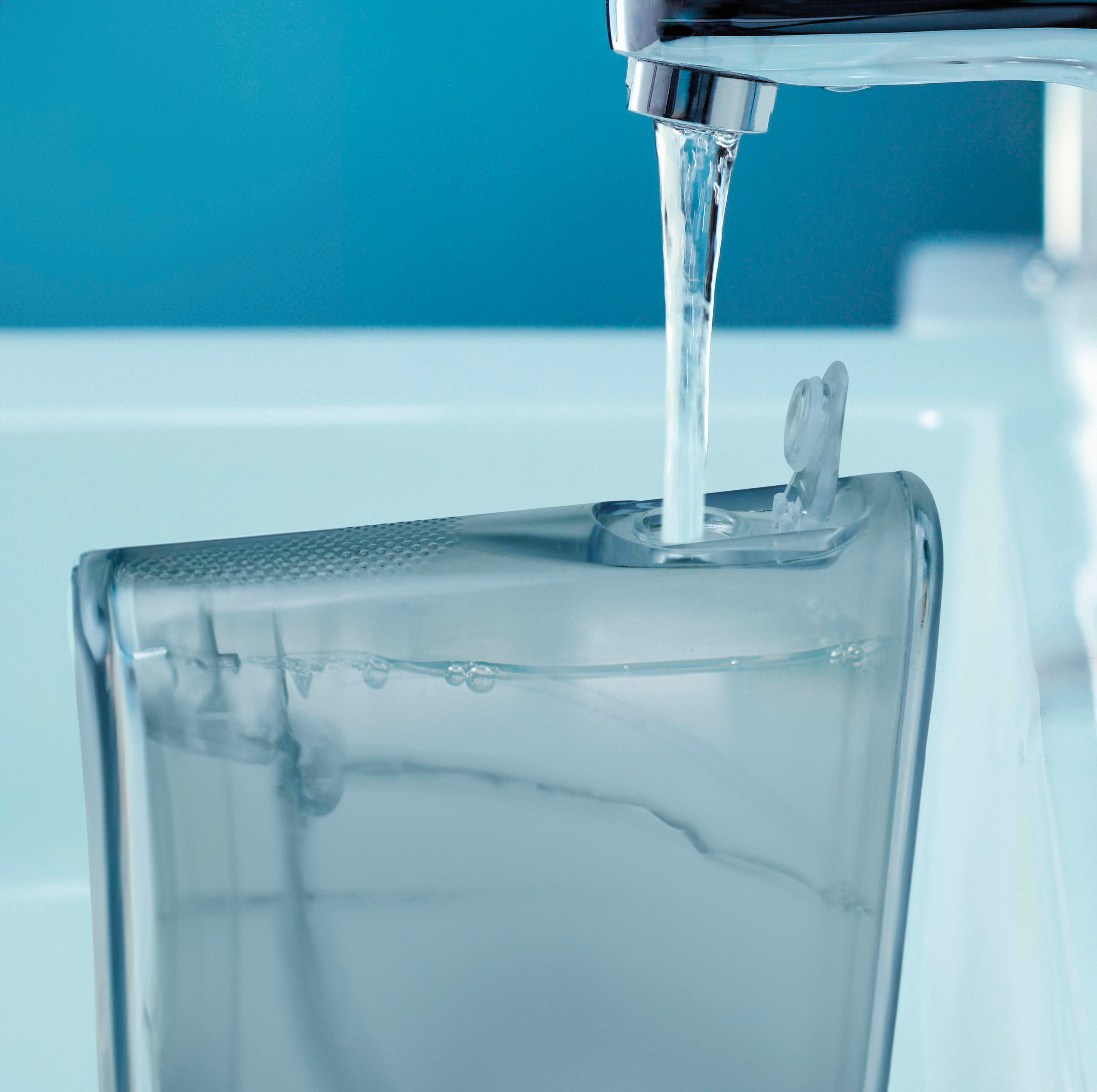 Wasser fließt in einen Behälter. Der Behälter ist transparent. Der Hintergrund ist blau.