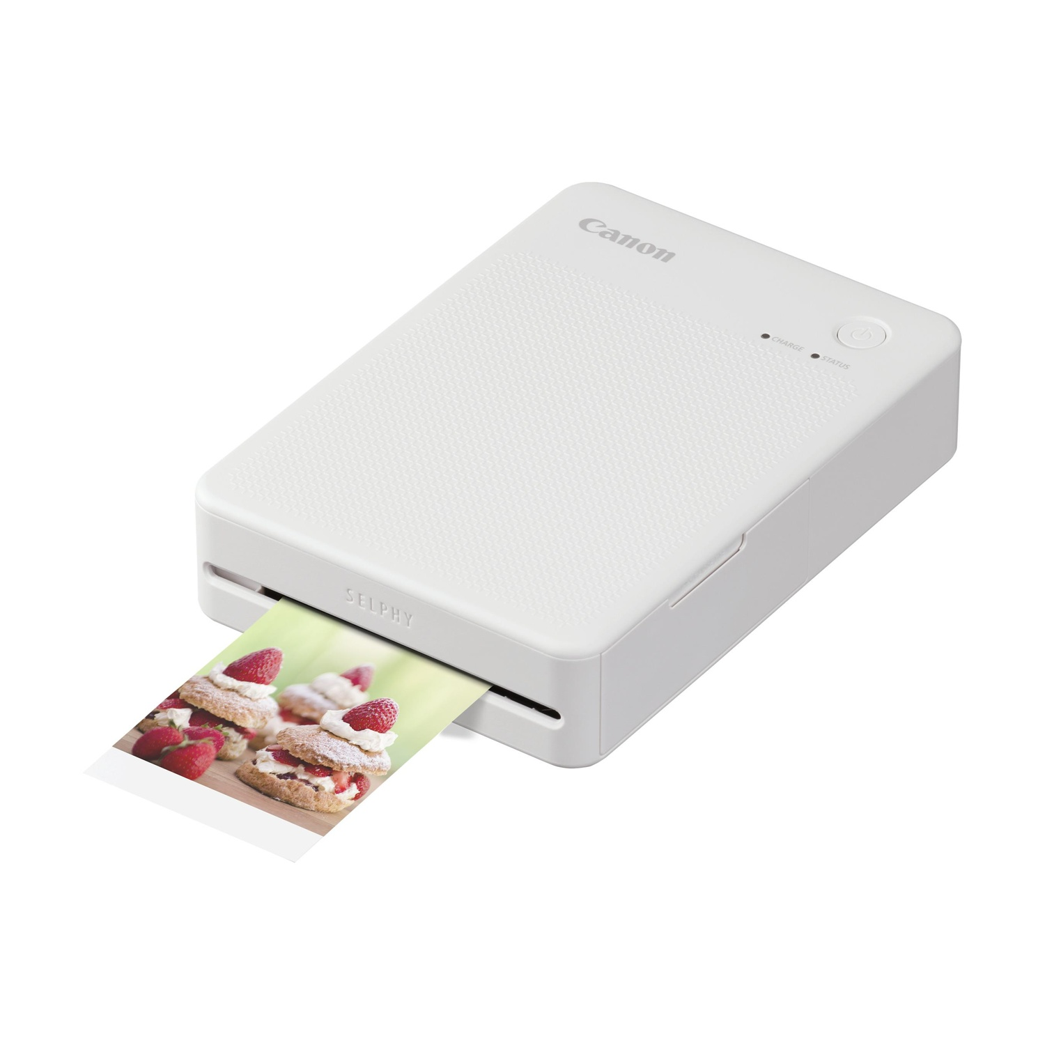Una stampante fotografica Canon Selphy bianca con una foto stampata. La stampante è su una superficie bianca.
