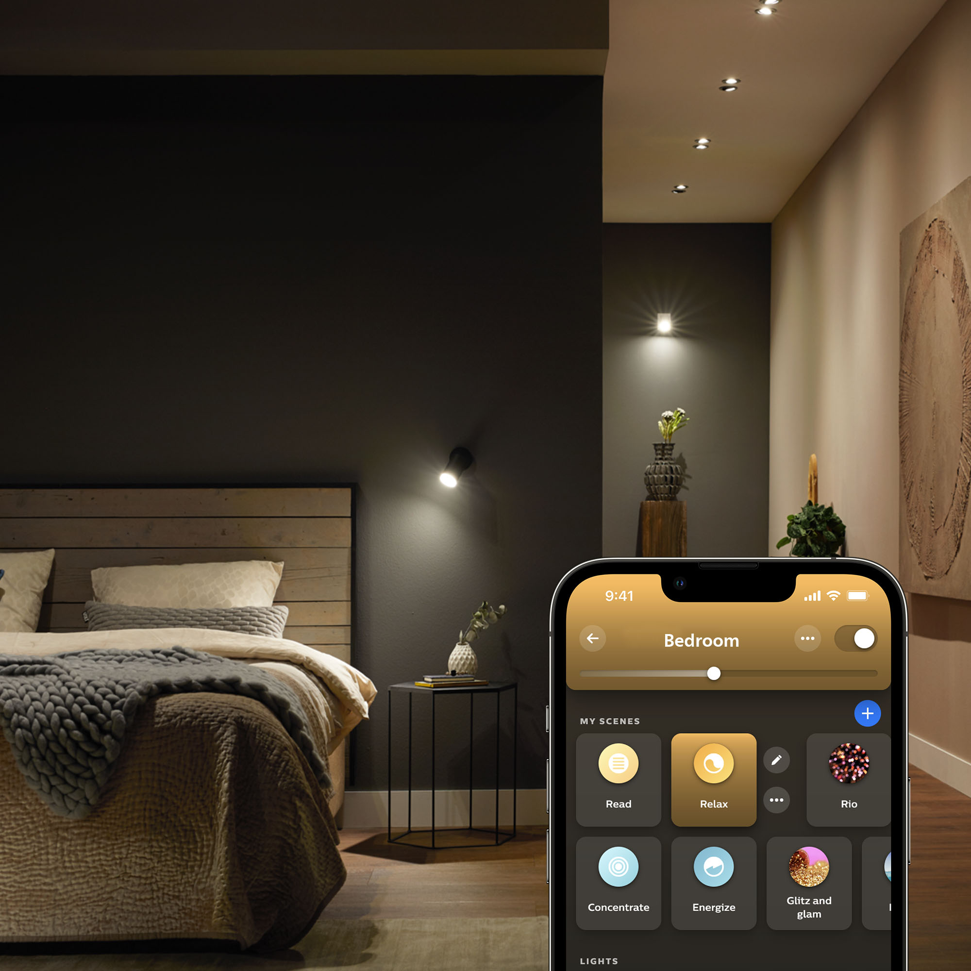 Schlafzimmer mit intelligenten Lichtern, die über eine Telefon-App gesteuert werden. Dunkle Wand und Bett.