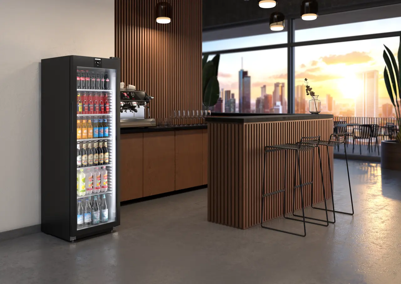 Schwarzer Kühlschrank in Bar-Umgebung, gefüllt mit Getränken. Modern.