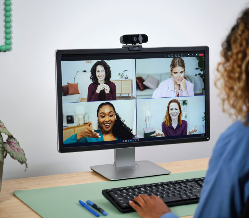 Négy ember videohívásban egy számítógép monitorán.