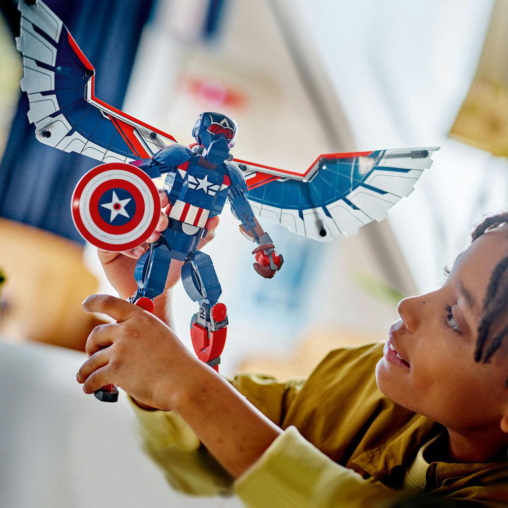 Ein Kind hält eine Captain America Lego Figur, zeigt das Modell und seine Details.