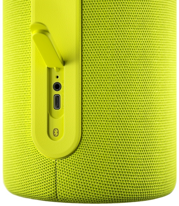 Zbliżenie żółto-zielonego głośnika z portami do ładowania i wejścia audio.