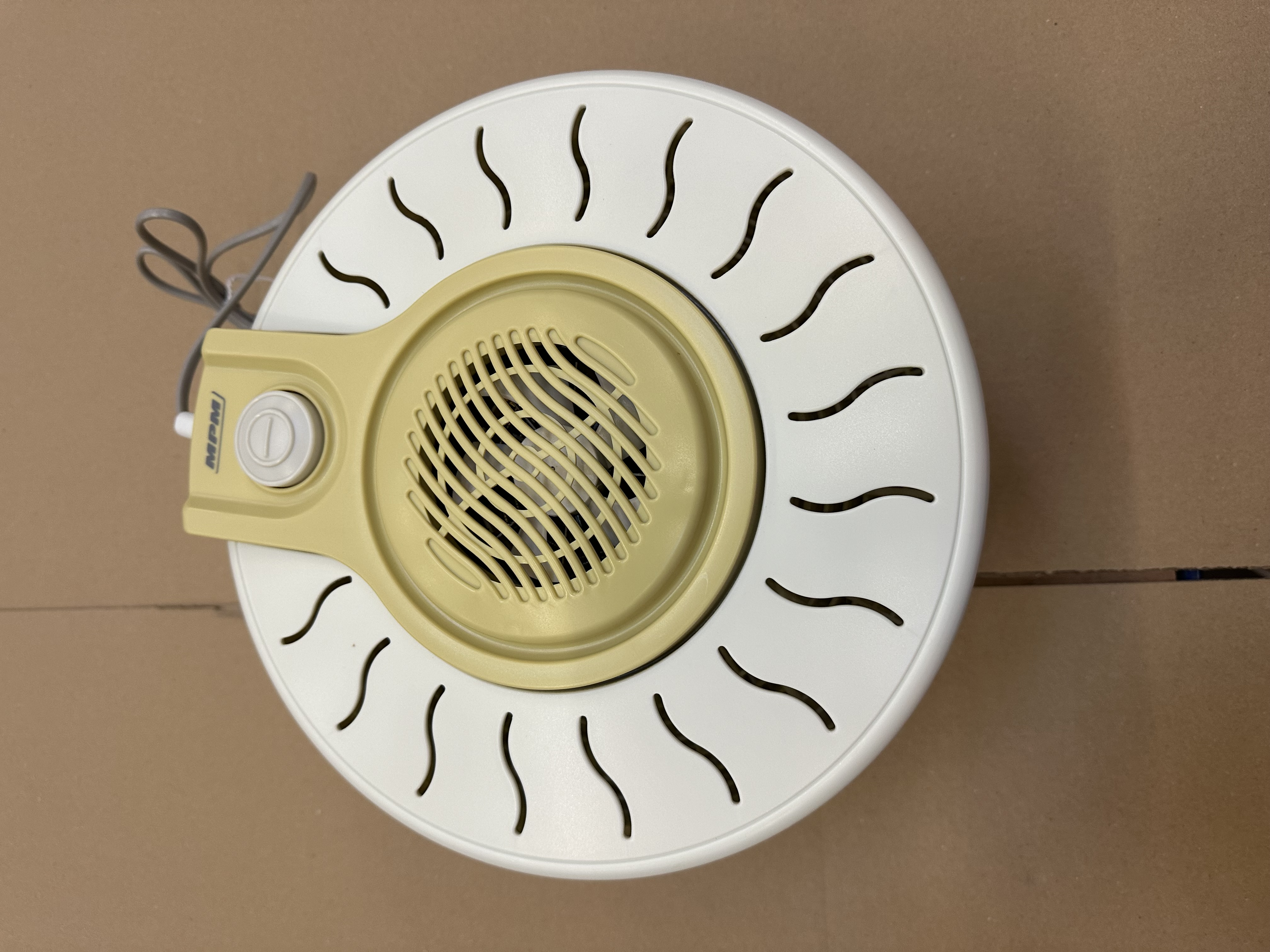 Biały i beżowy oczyszczacz powietrza o okrągłym kształcie z otworami wentylacyjnymi.