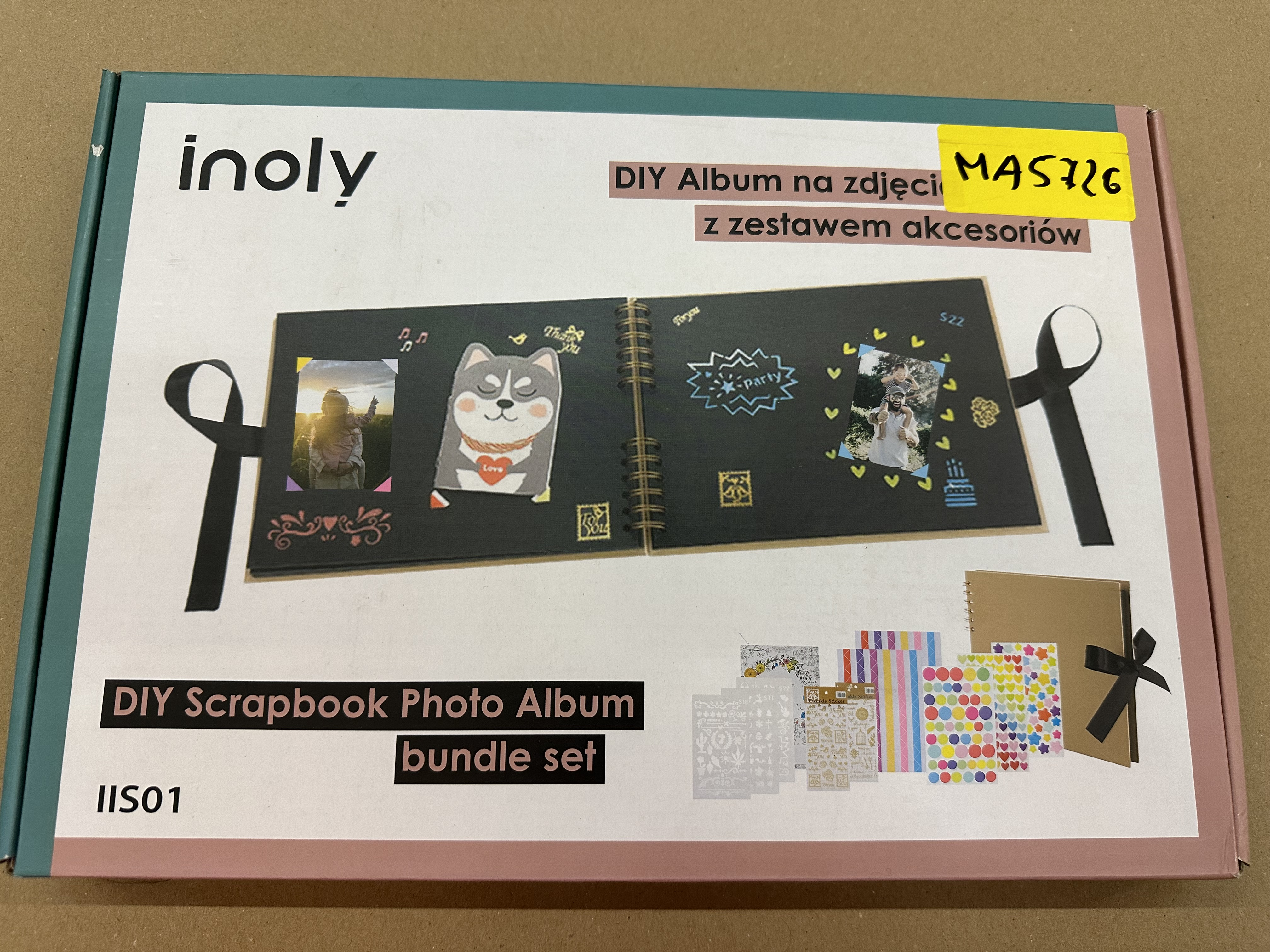 Zestaw do scrapbookingu. Pudełko pokazuje gotowy album i akcesoria ze zdjęciem.