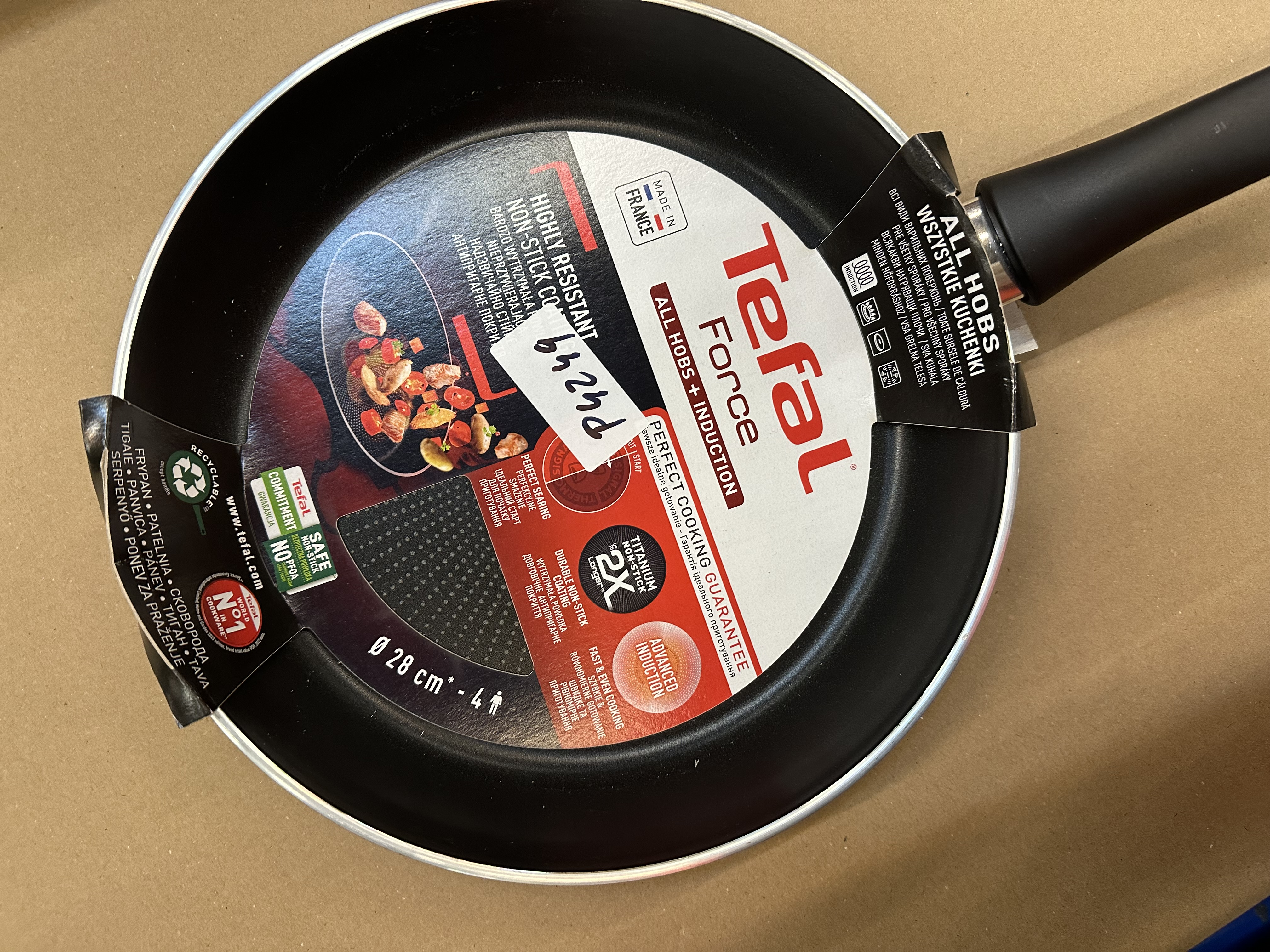 Patelnia Tefal z etykietą, czarna patelnia, uchwyt i informacje o produkcie.
