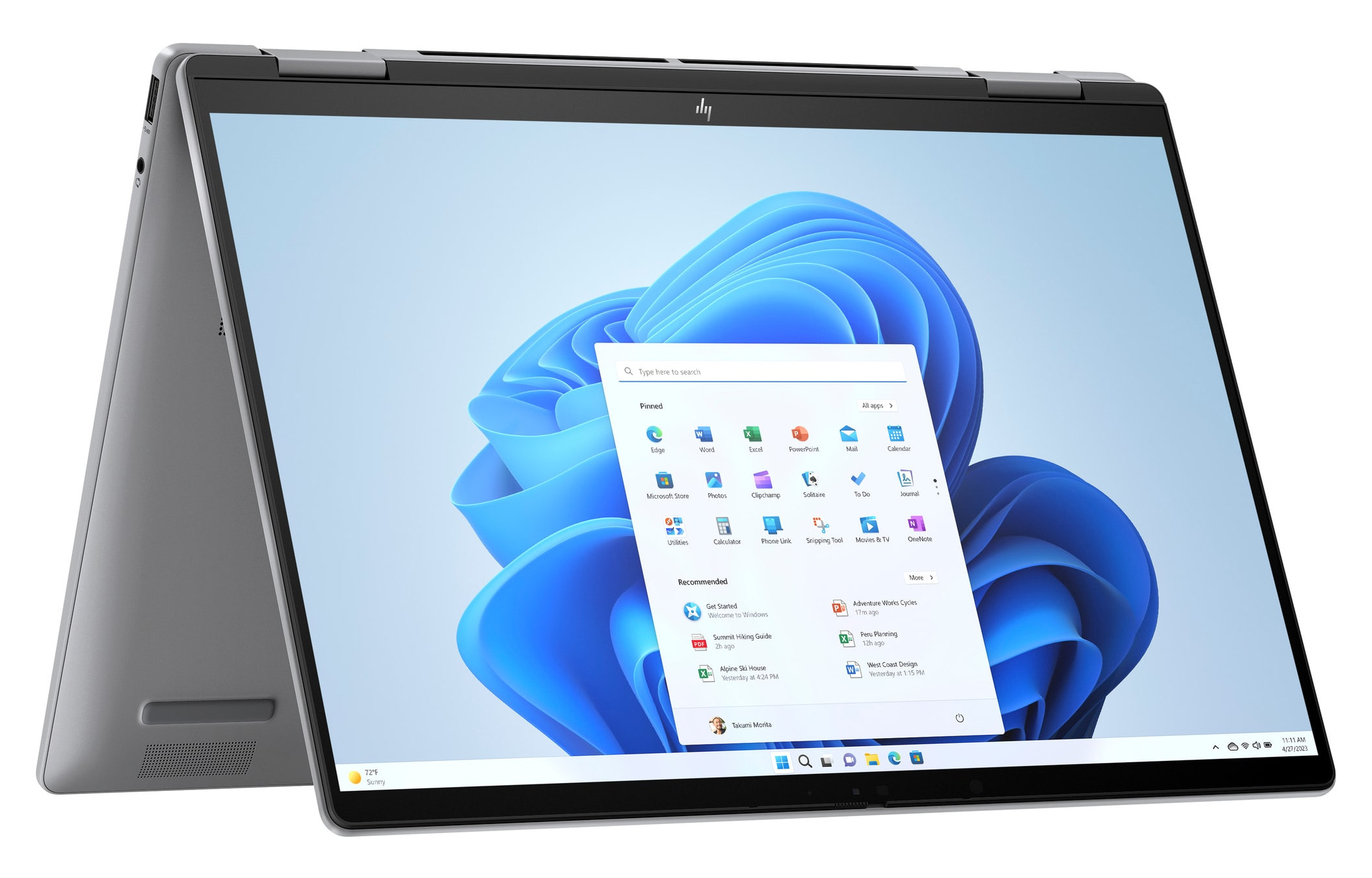 Srebrny laptop z otwartym ekranem, pokazujący interfejs Windows 11. Widoczne aplikacje i ikony.