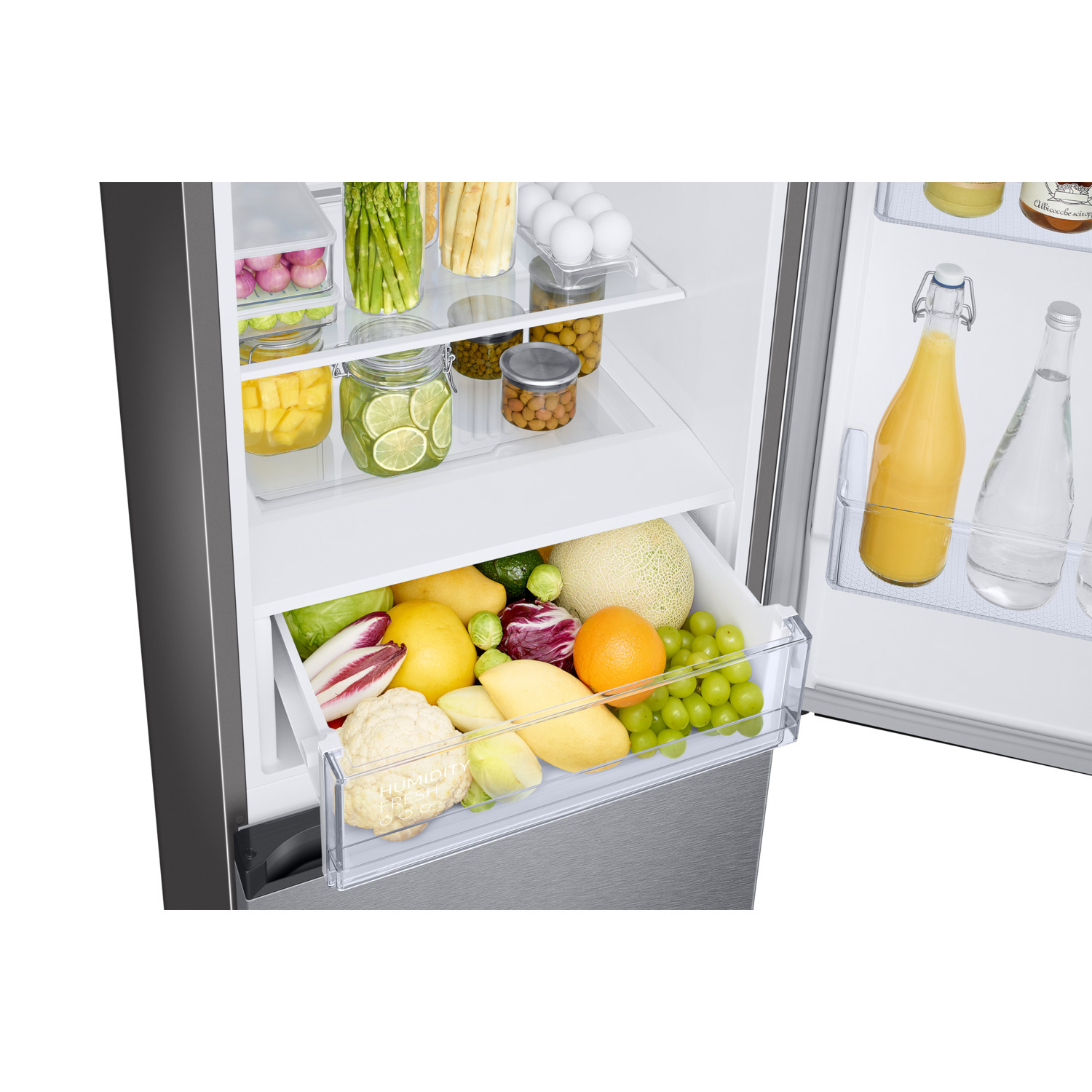 Open fridge showing fruit and vegetables in drawers, with eggs and jars on shelves.