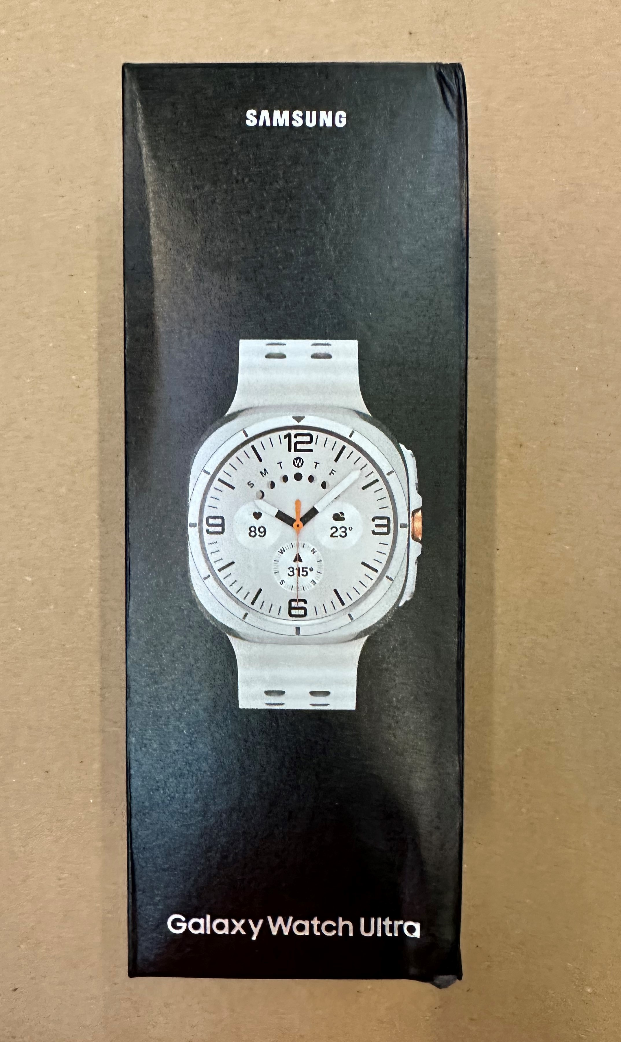 Czarne pudełko ze zdjęciem białego smartwatcha z przodu.