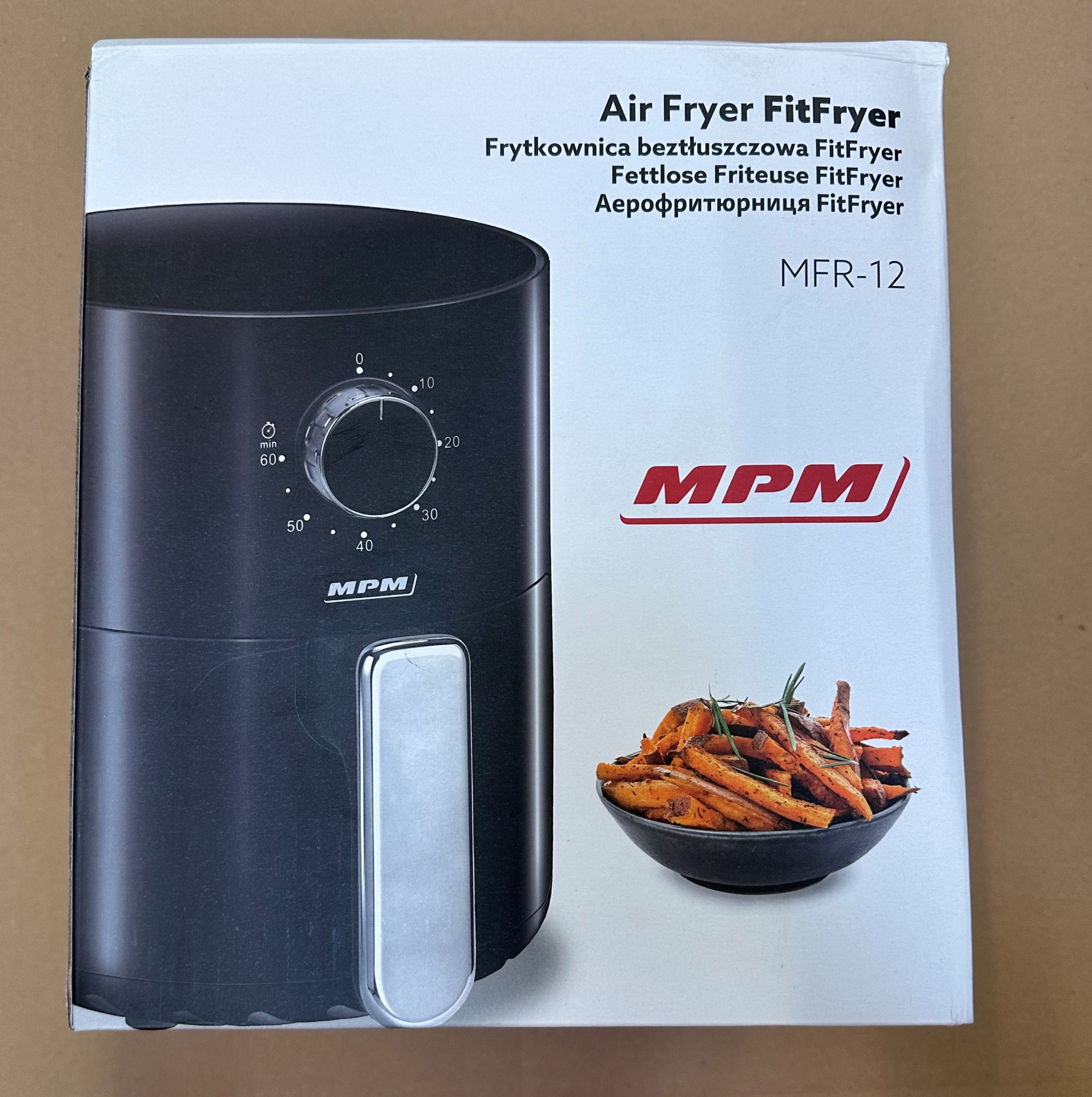 Czarne pudełko frytkownicy powietrznej ze zdjęciem jedzenia. Białe tło.