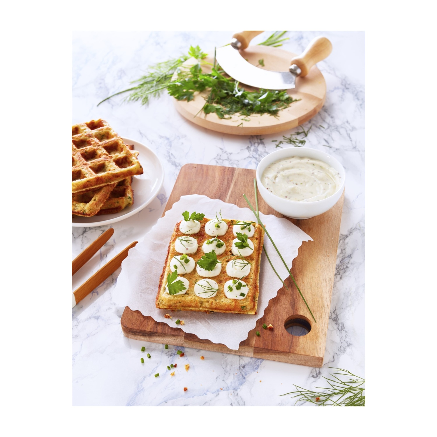 Waffle con condimenti e una ciotola di salsa su un tagliere.