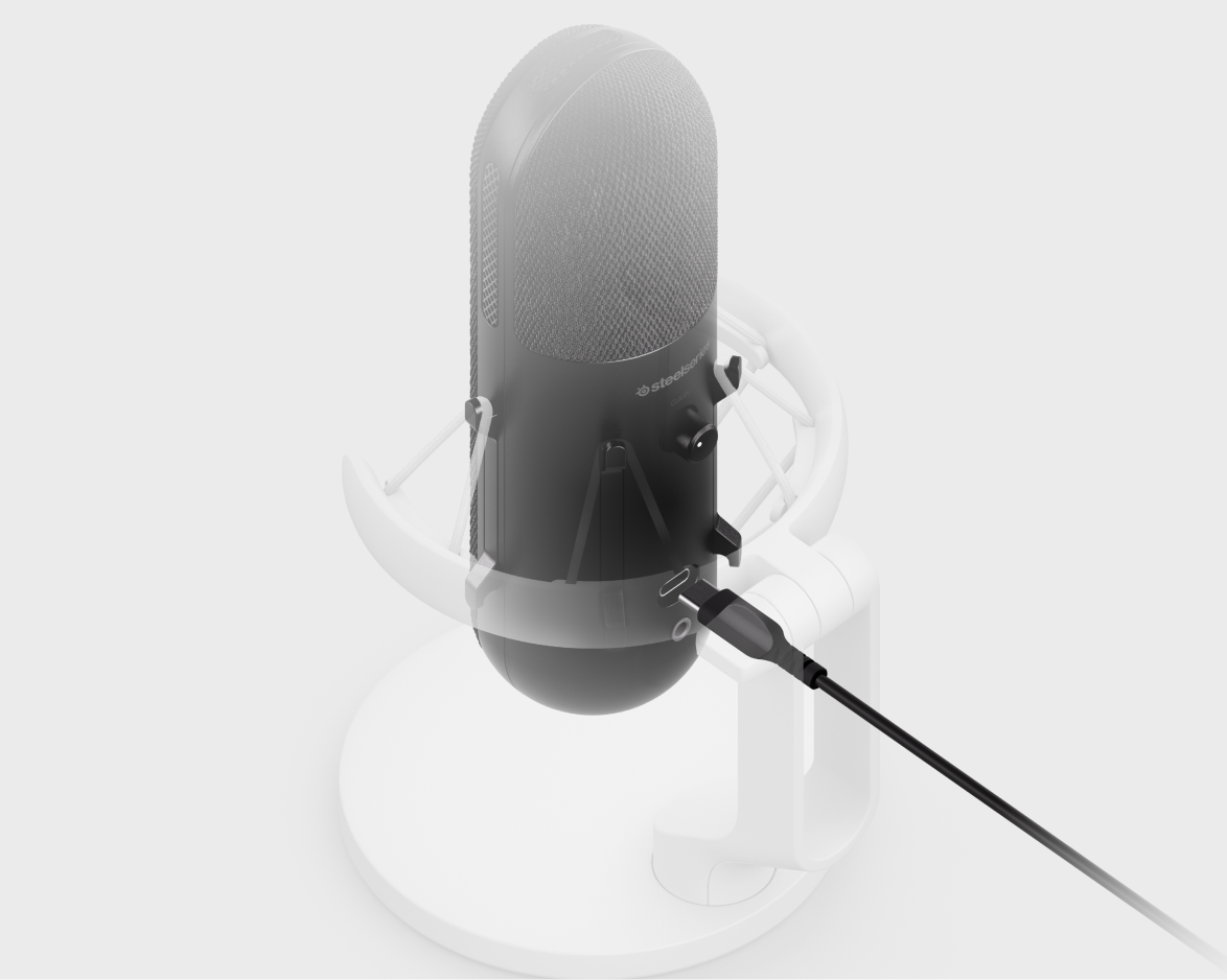 Micrófono SteelSeries negro sobre un soporte, conectado a un cable negro sobre fondo blanco borroso.