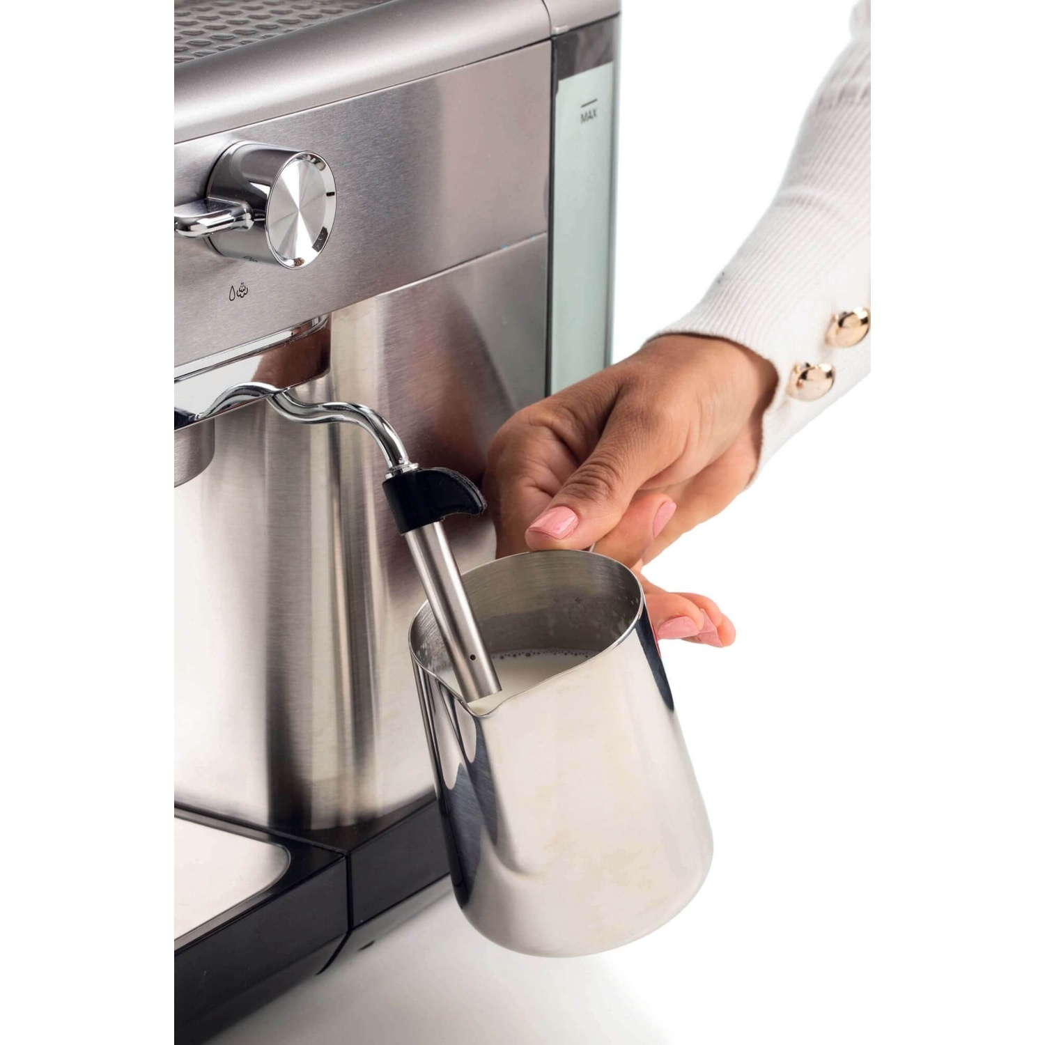 Persona che monta il latte con macchina espresso. Brocca d'argento.