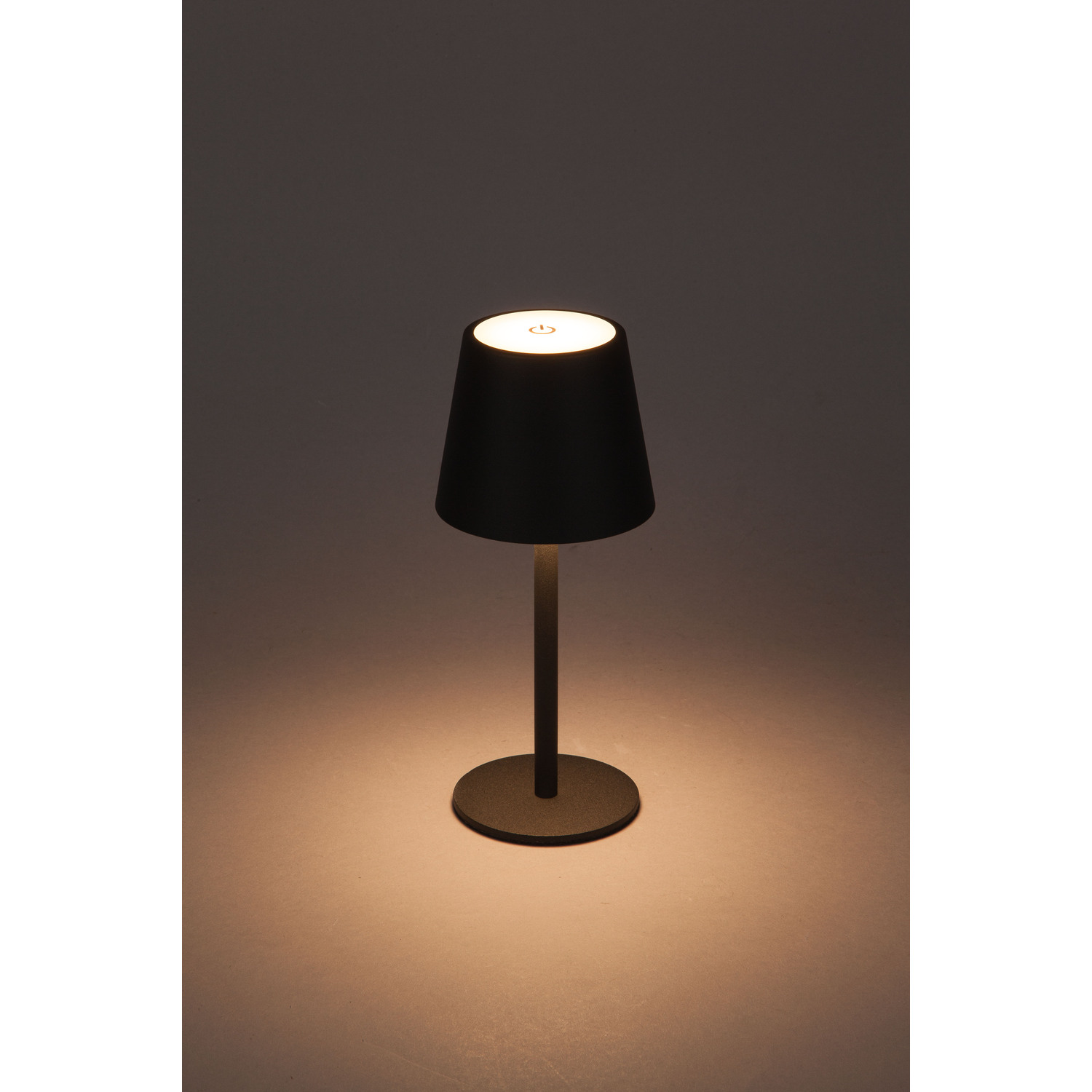 A black lamp with a white light and a simple design on a light background.