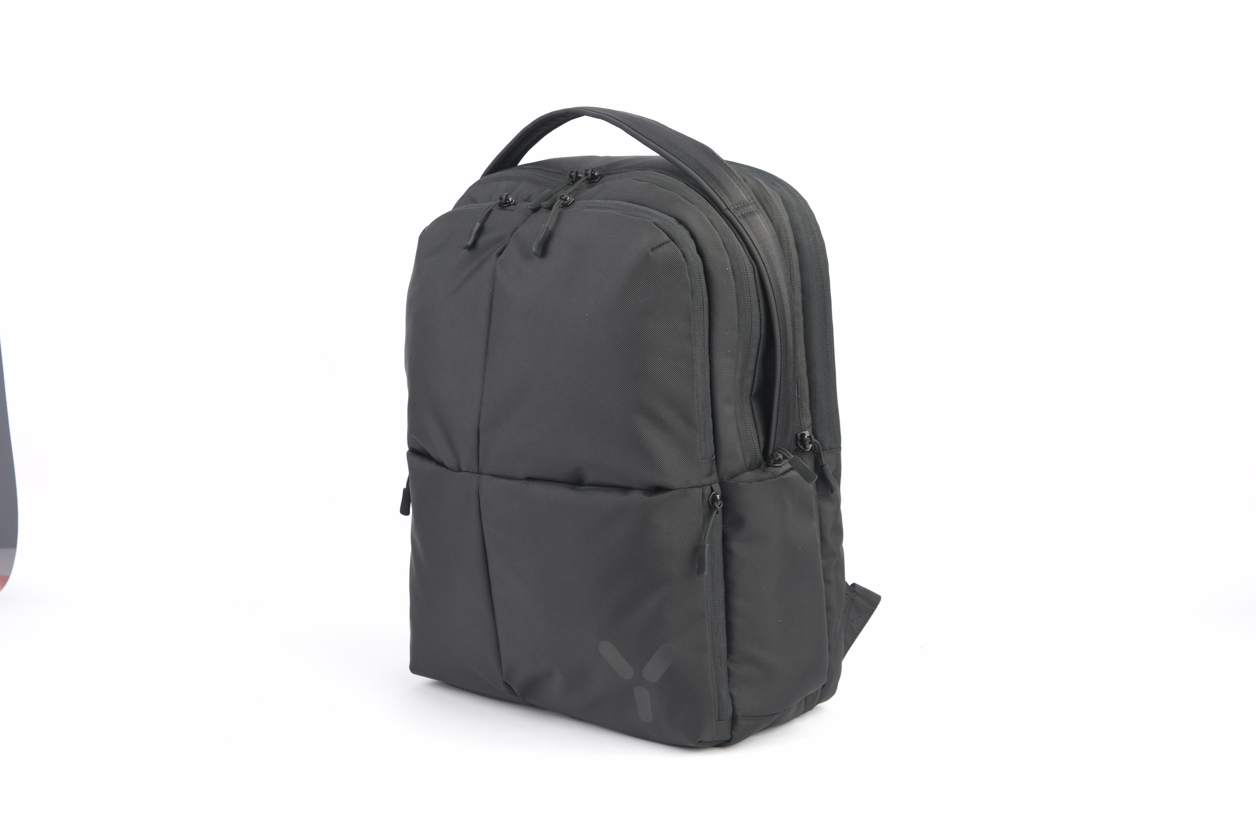 Schwarzer Rucksack auf weißem Hintergrund. Er hat mehrere Fächer und Reißverschlüsse.