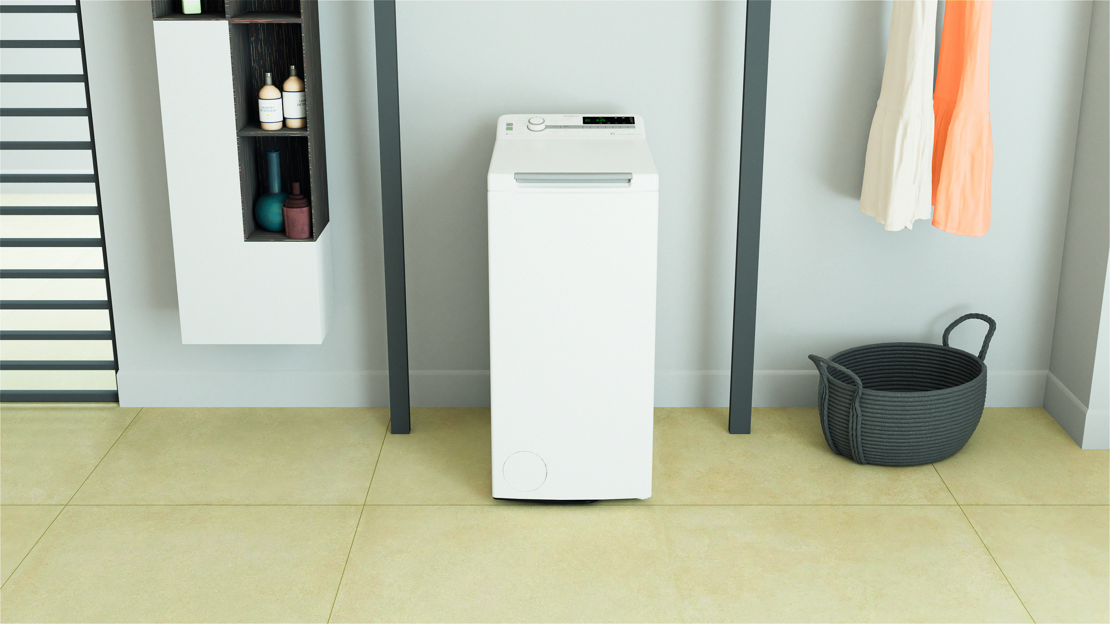 Biała pralka w pokoju. Wieszak i kosz na pranie są obecne.