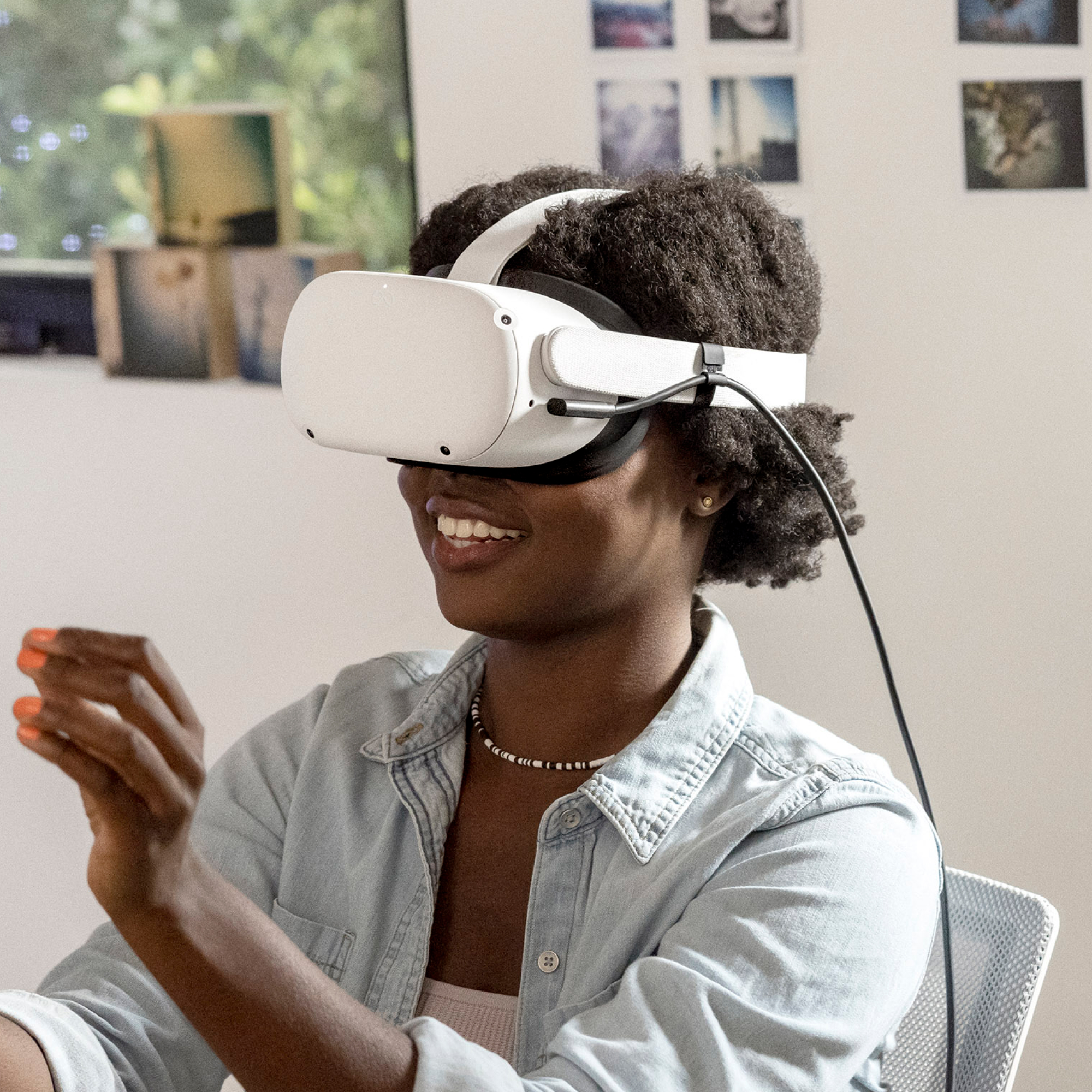 Frau mit VR-Headset lächelt. Lichtdurchfluteter Raum. Hält die Hände.