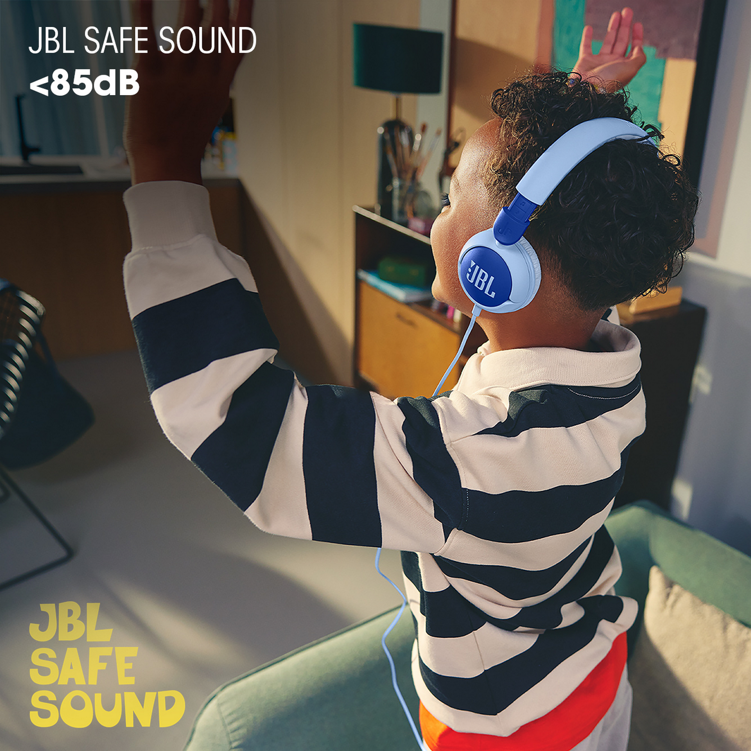 Un niño con auriculares JBL azules, con texto que indica niveles de sonido seguros.