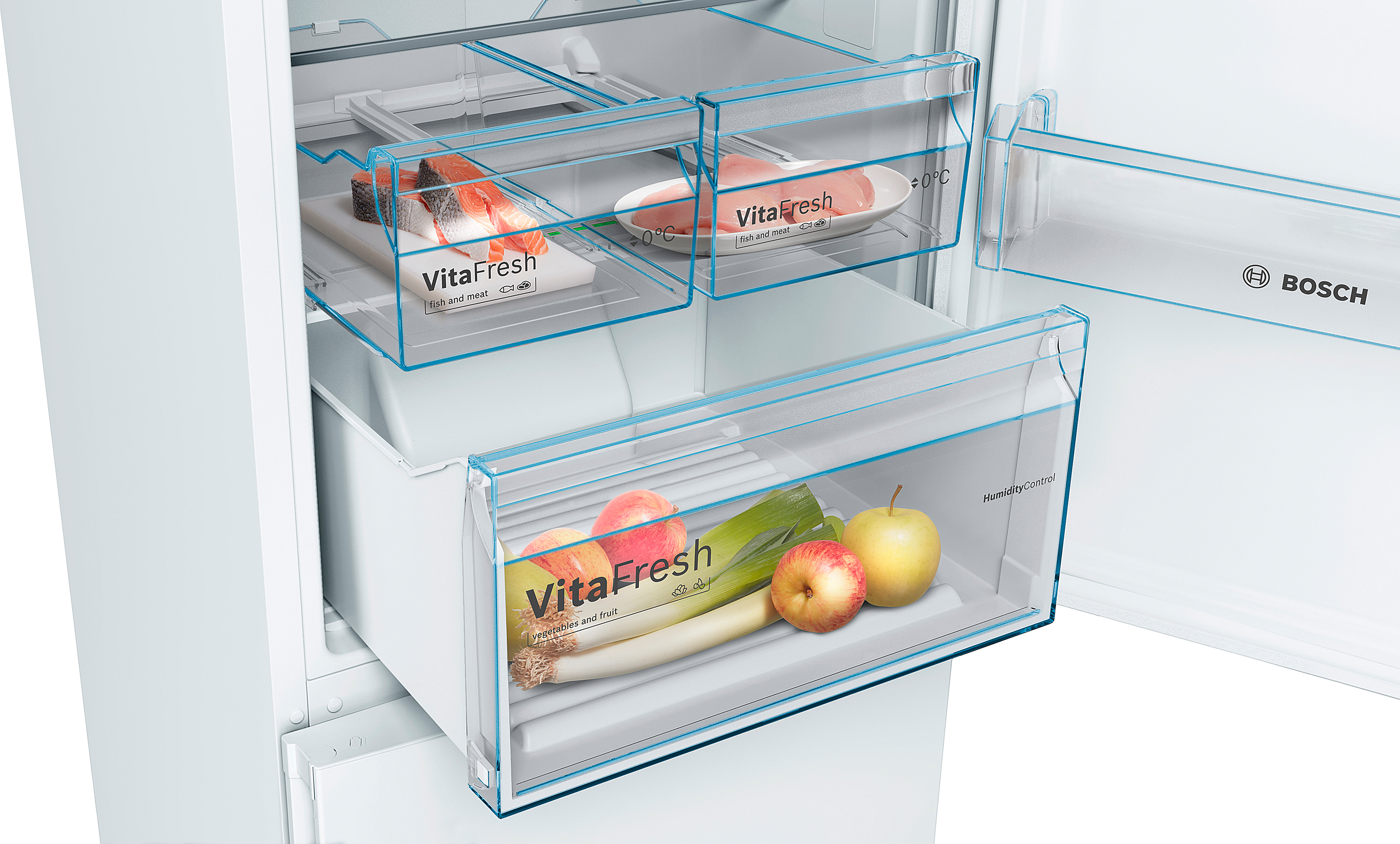 Un refrigerador con cajones abiertos que muestran el almacenamiento de alimentos. Se ven manzanas, puerros y salmón.