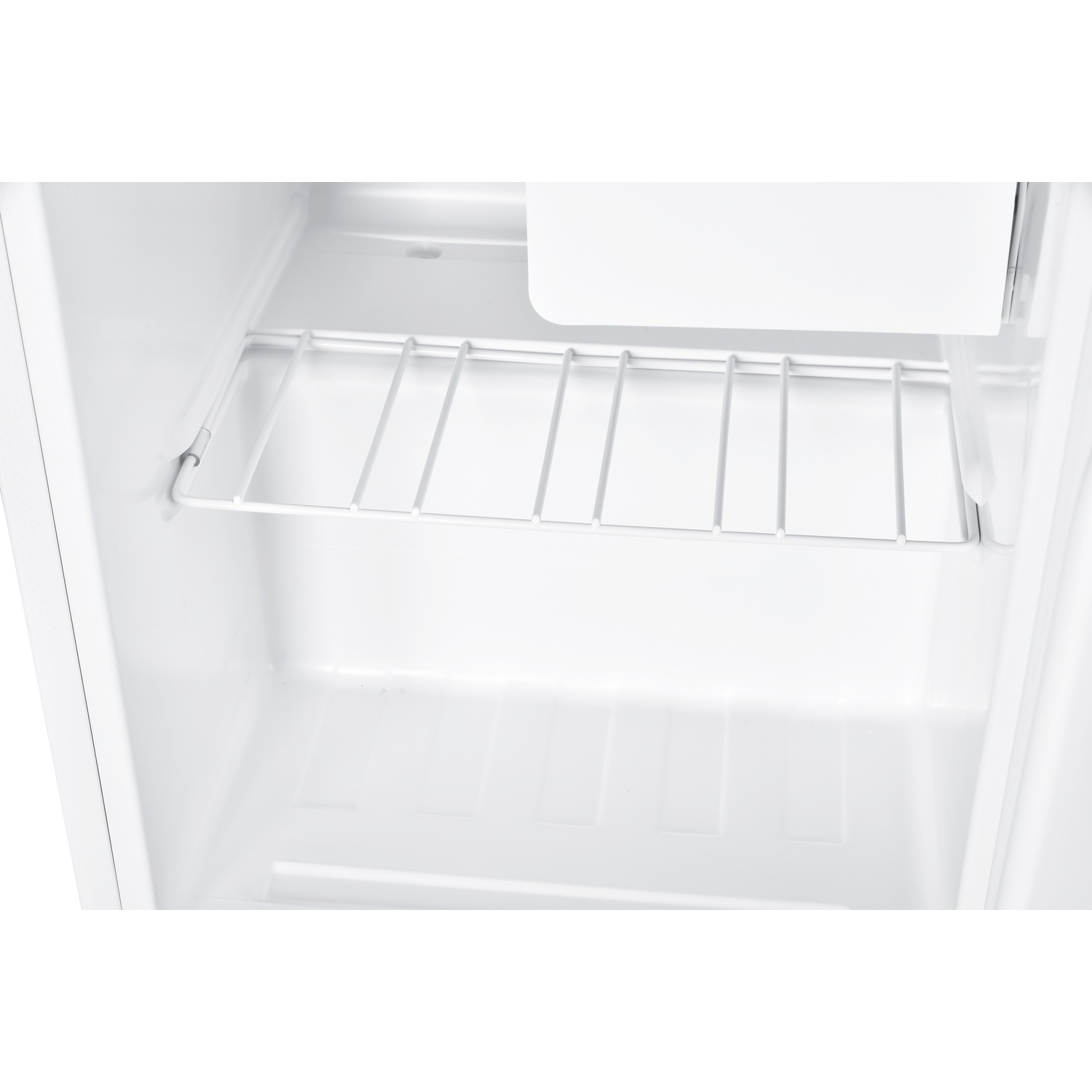 Interno di un frigorifero bianco. Sono visibili un ripiano e la sezione inferiore.