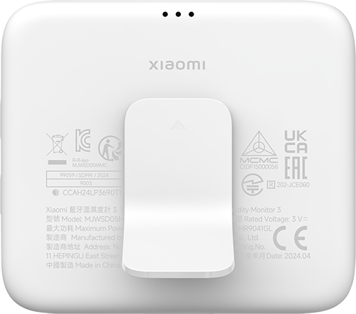 Egy fehér Xiaomi eszköz állvánnyal, címkékkel és rögzítőcsappal, fehér háttér előtt.