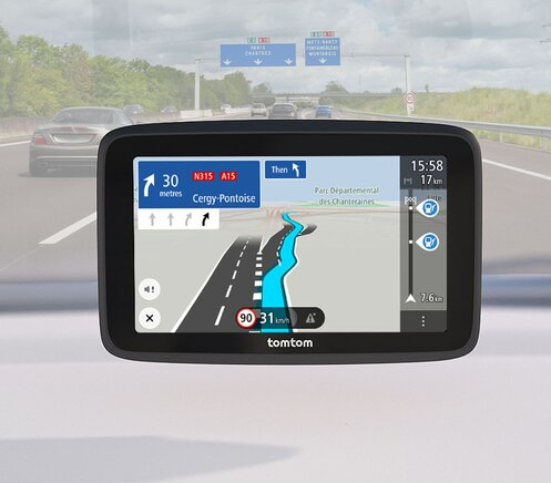 Urządzenie nawigacji GPS pokazujące mapę drogową. Jest w samochodzie, z autostradą w tle.