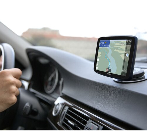 Deska rozdzielcza samochodu z zamontowanym GPS, wyświetlająca mapę i nawigację.