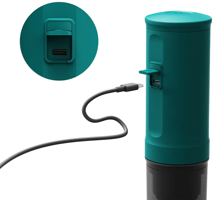 Türkiz henger USB-porttal és töltőkábellel. A kábel csatlakoztatva van.