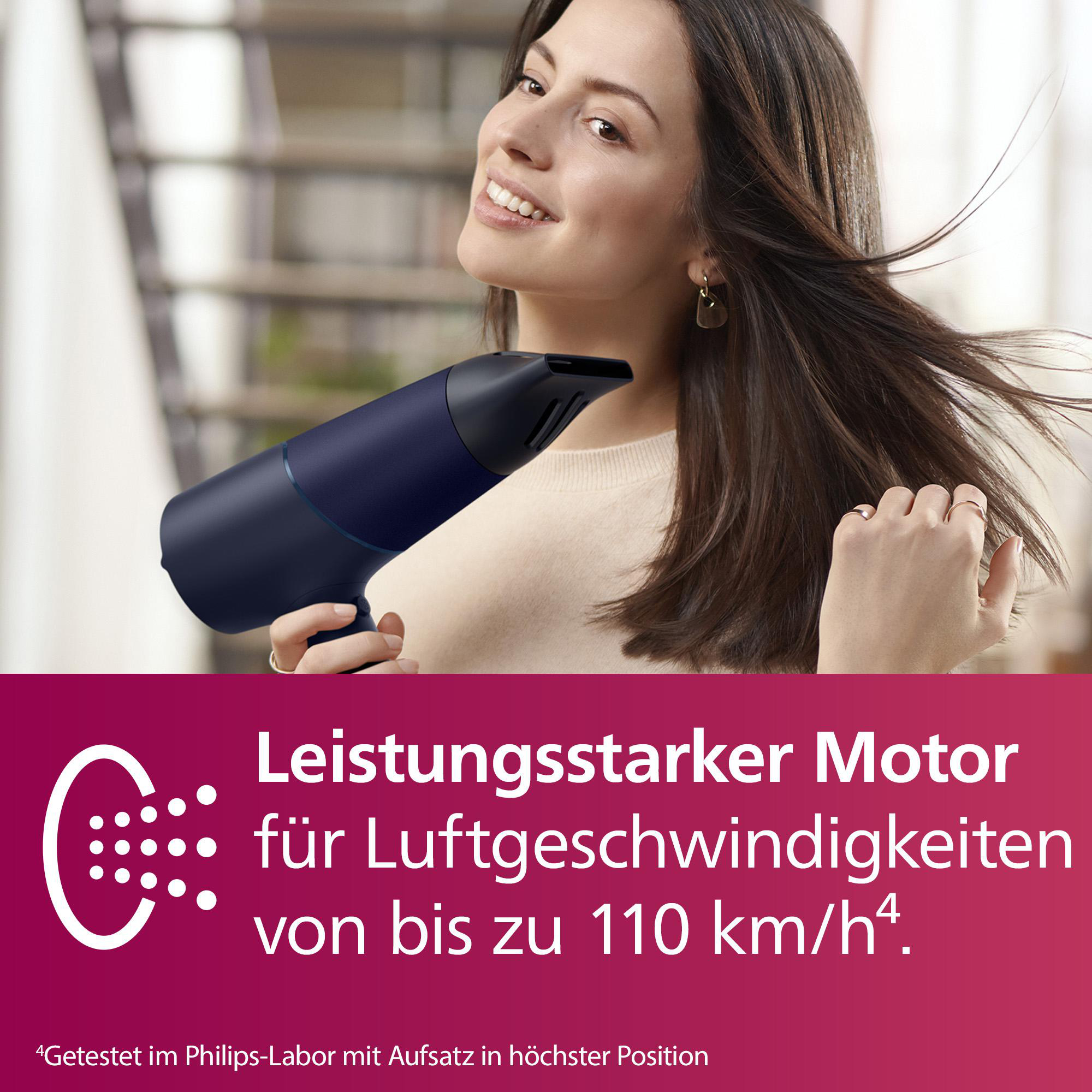 Frau mit einem dunkelblauen Haartrockner in ihren Haaren. Text: Leistungsstarker Motor für Luftgeschwindigkeiten bis zu 110 km/h.