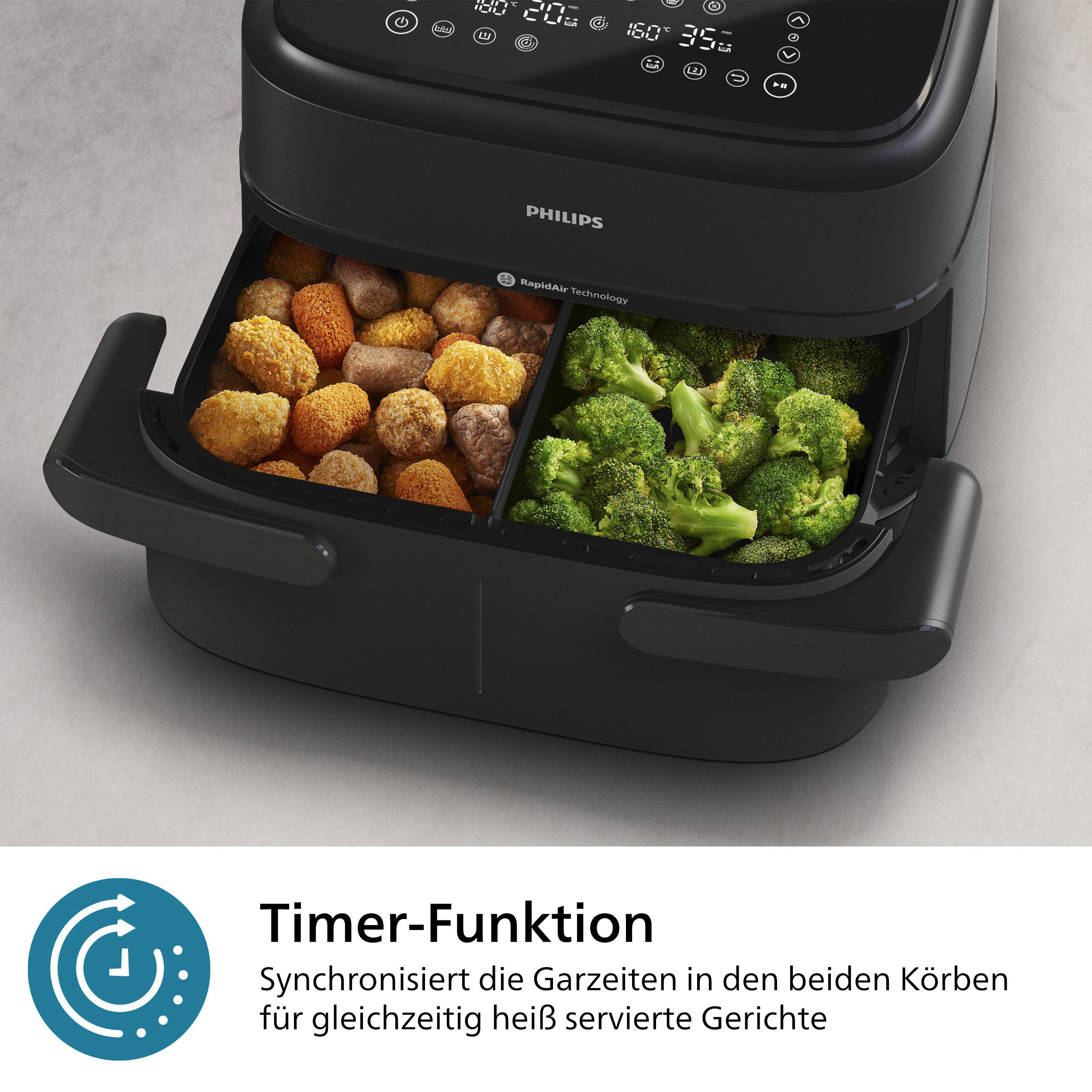 Schwarze Philips Heißluftfritteuse mit zwei Fächern, eines mit Frittiertem, eines mit Brokkoli.