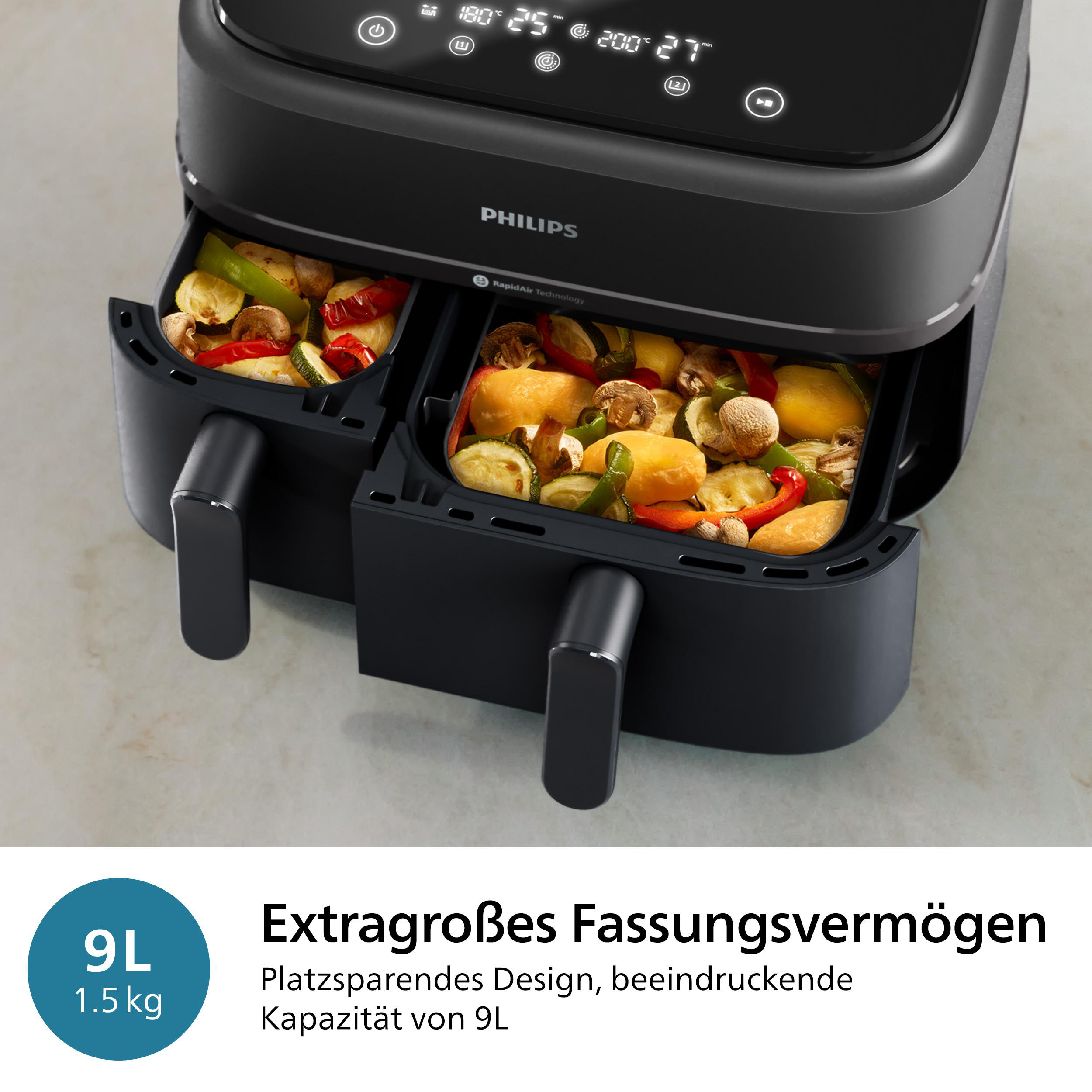 Schwarze Heißluftfritteuse mit zwei Fächern, Essen darin. Weiße Oberfläche, Text: Extragroßes Fassungsvermögen.