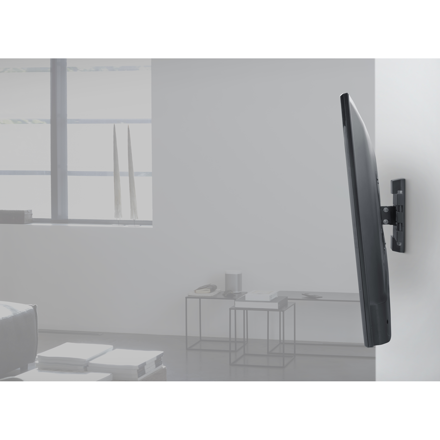 Tv aan de muur gemonteerd. De tv is donker, met een minimalistisch ontwerp.