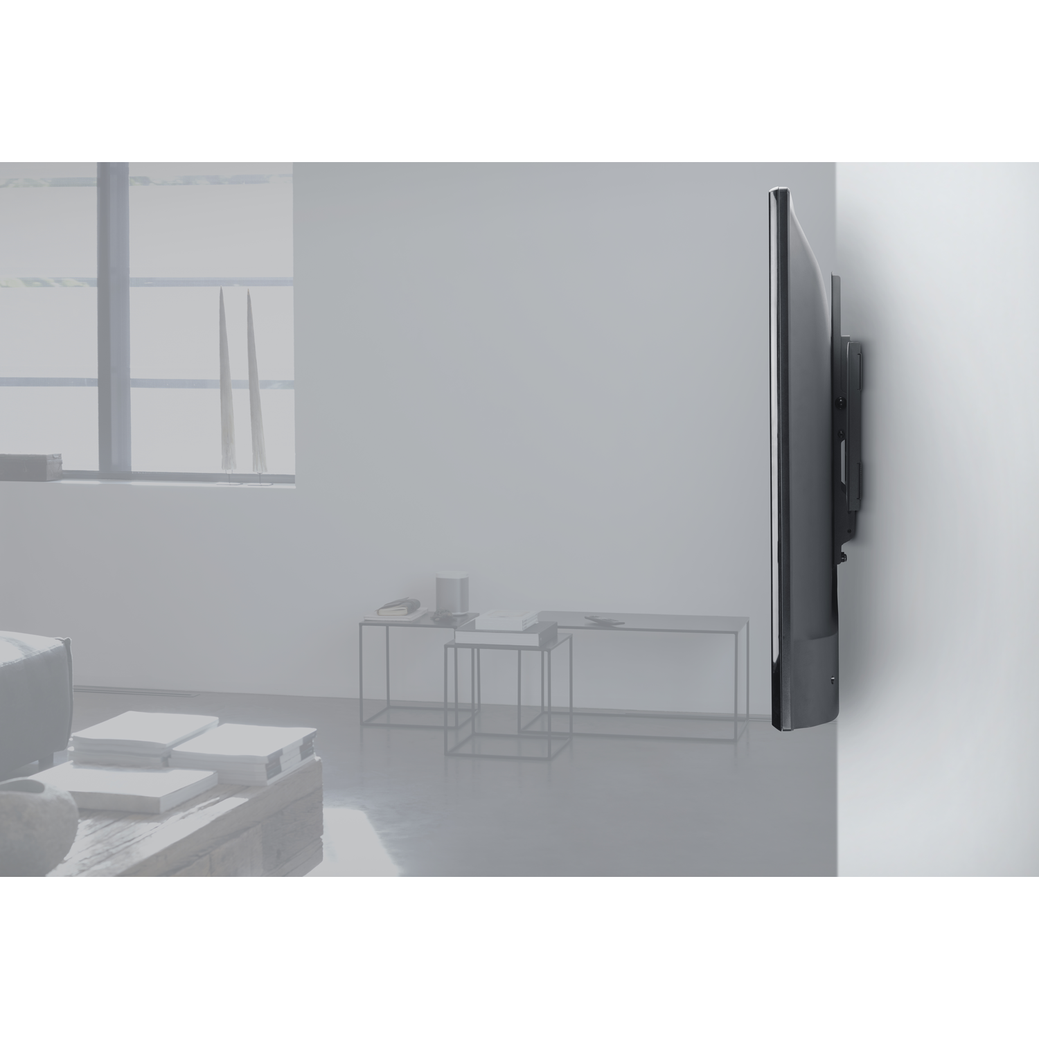 Een tv is aan een muur gemonteerd en toont het zijprofiel in een woonkamer.