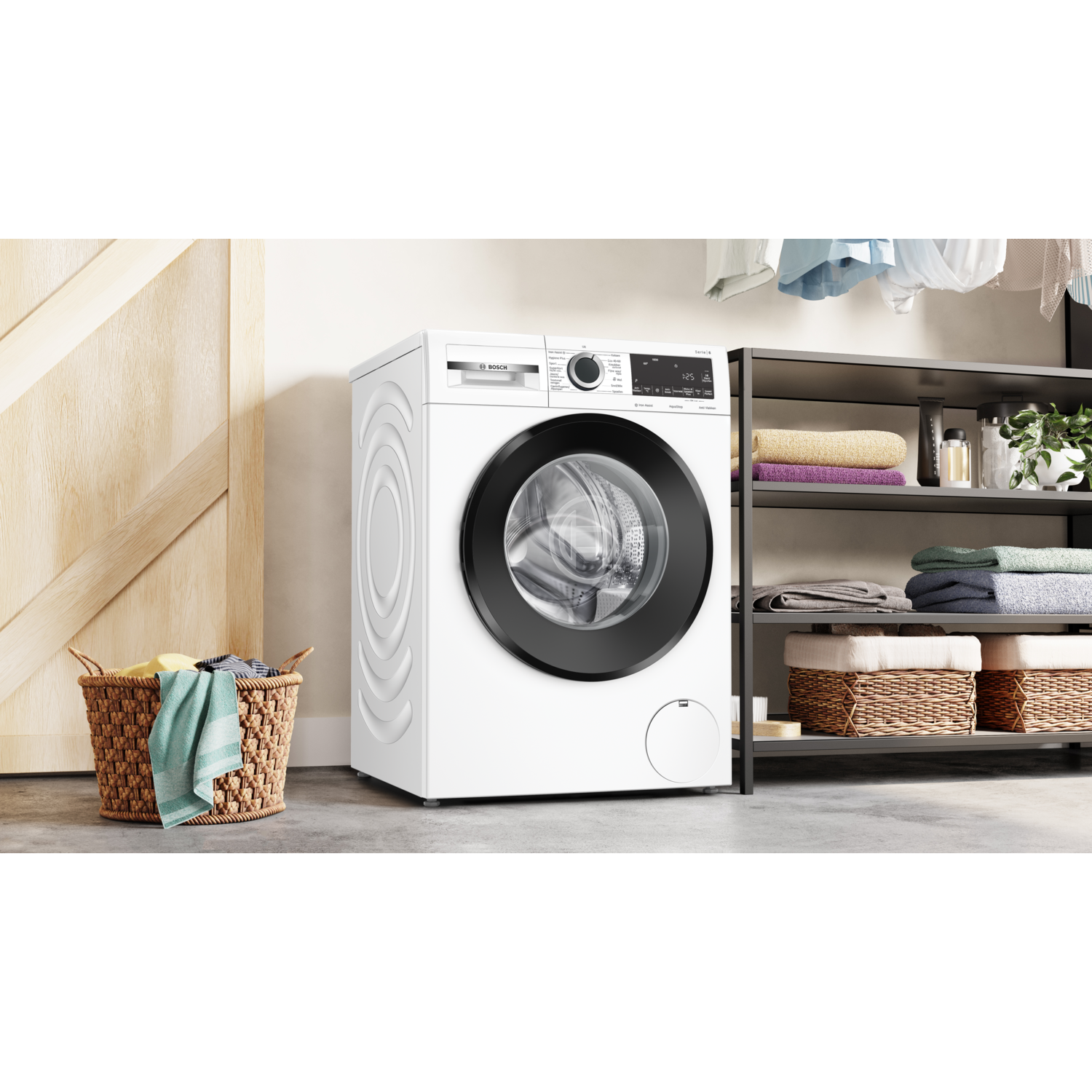 Een witte wasmachine met een zwarte deur. Het staat in een wasruimte met een houten deur en een mand.