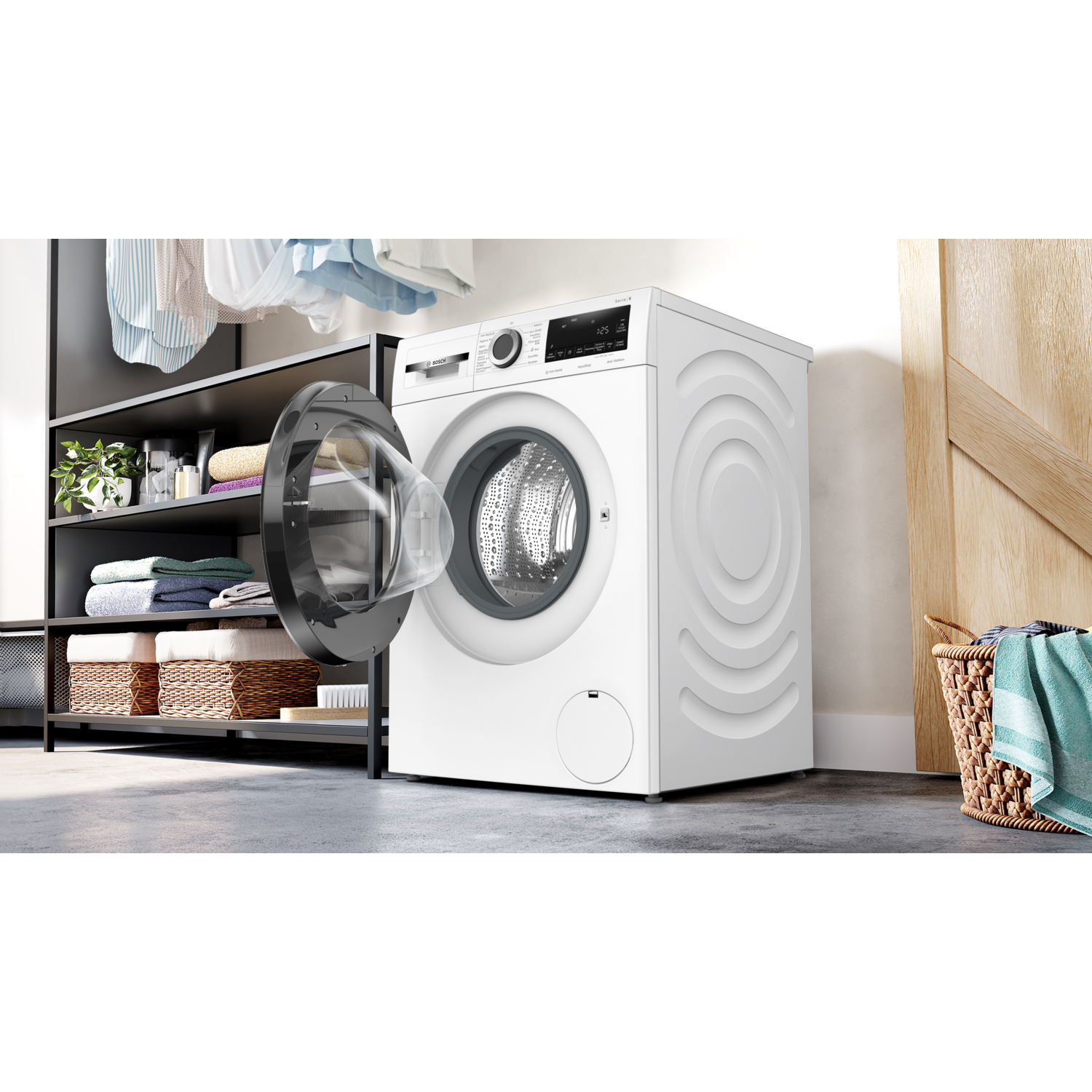 Een witte wasmachine met een open deur. Waskamer met kleding en mand.