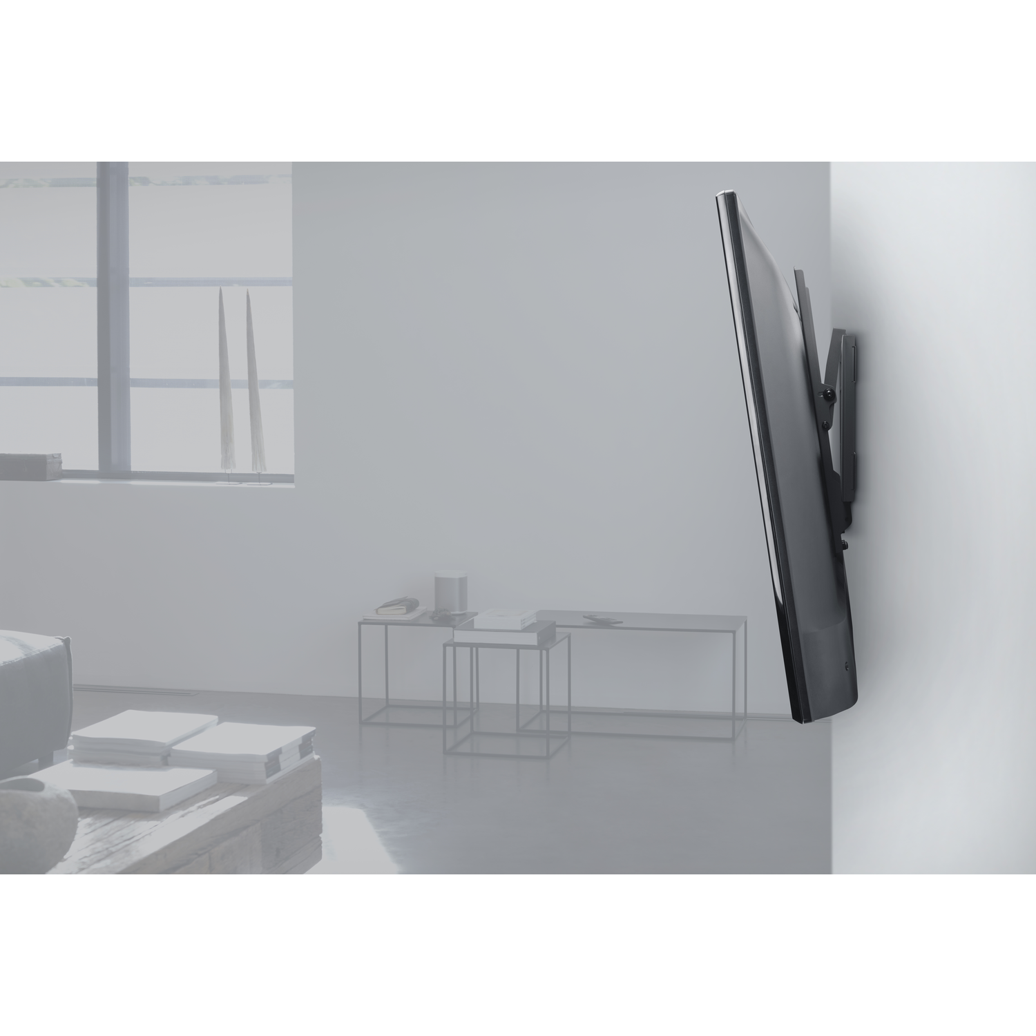 TV gemonteerd op witte muur. Woonkamer op de achtergrond.