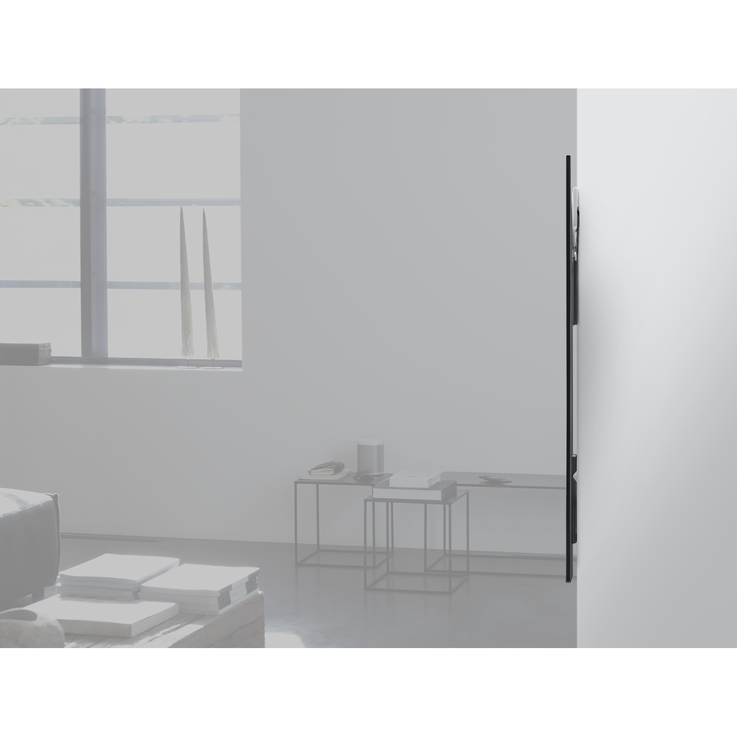 Een modern interieur. Een muur met een zijdelings gemonteerde tv. Tafels en meubels.