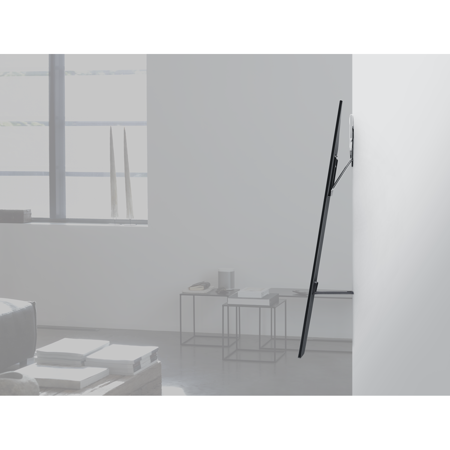 Moderne woonkamer met een tv aan een witte muur en bijzettafels.