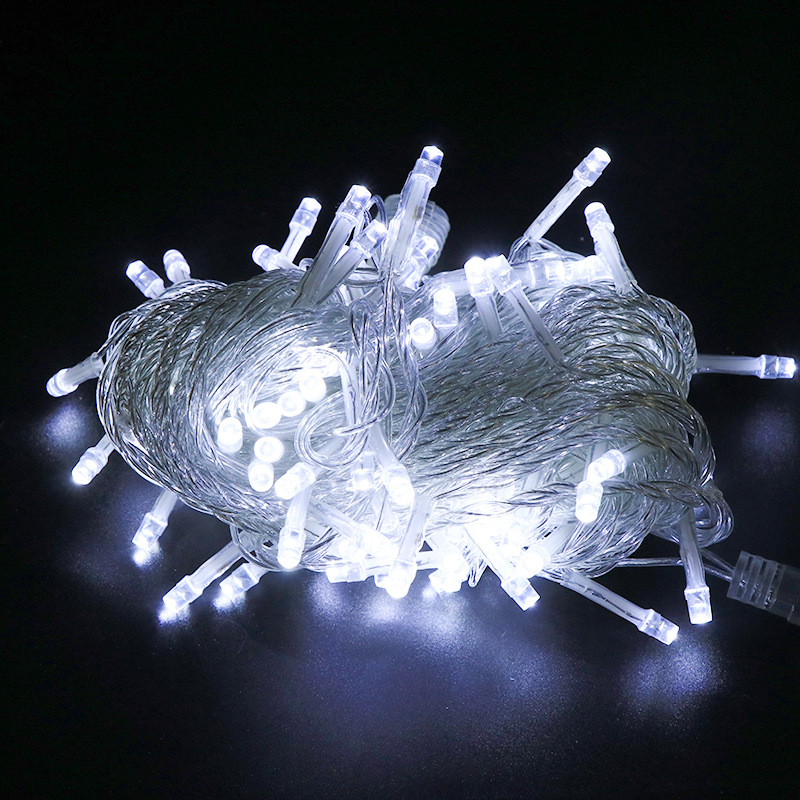 Poplątana wiązka białych lampek choinkowych LED świecących jasno na ciemnym tle.