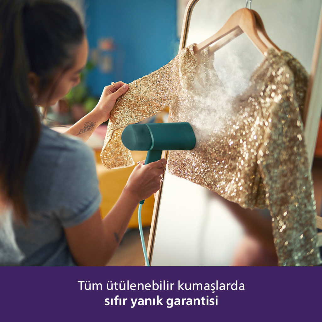 Kadın, altın pul işlemeli bir ceketi turkuaz bir buhar makinesiyle buharlıyor. Metinde 'sıfır yanma garantisi' yazıyor.